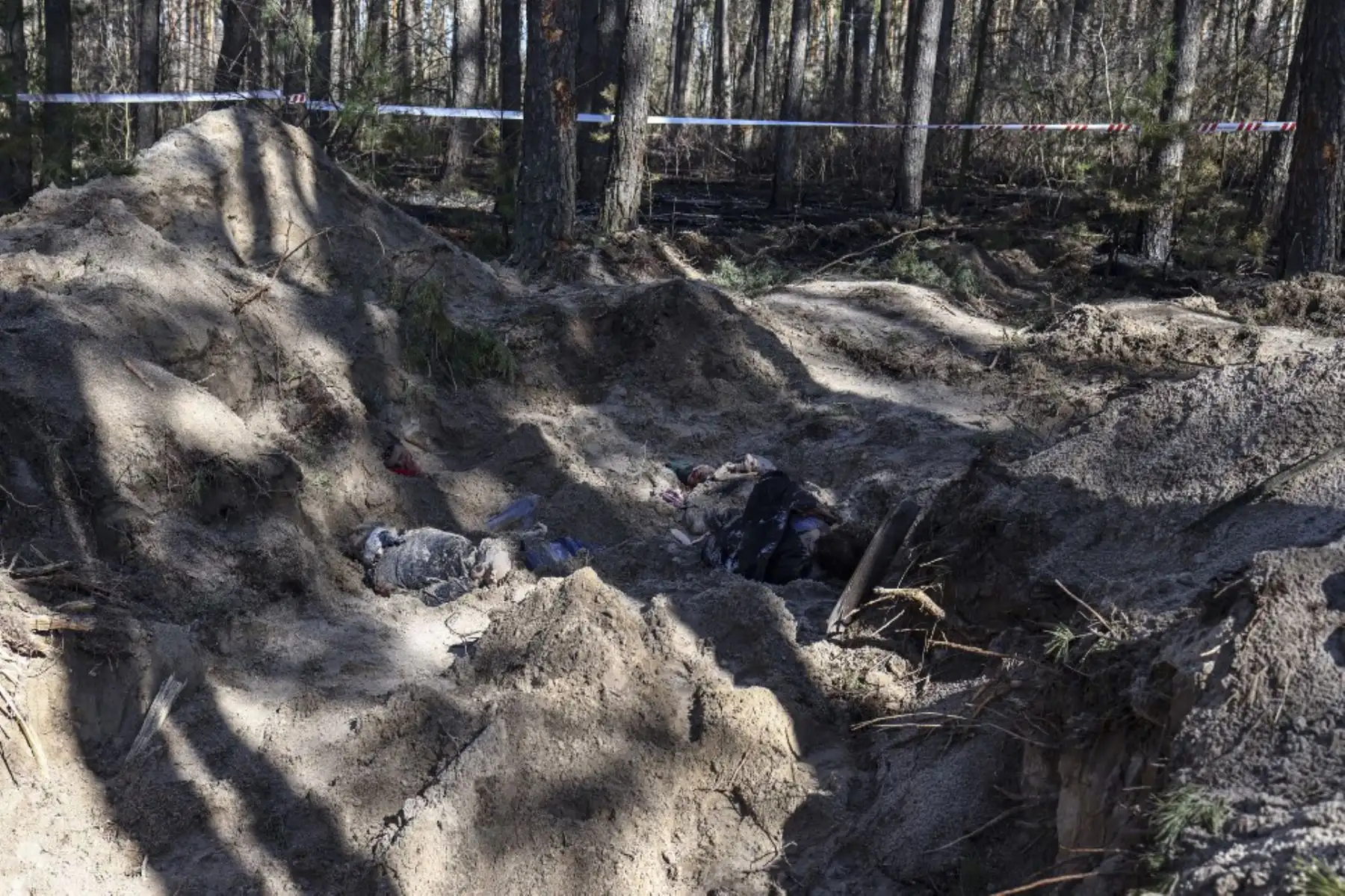 Los cuerpos se ven en una fosa común en la aldea de Motyzhyn, distrito de Bucha del oblast de Kiev, al oeste de la capital de Ucrania, Kiev. Foto: AFP