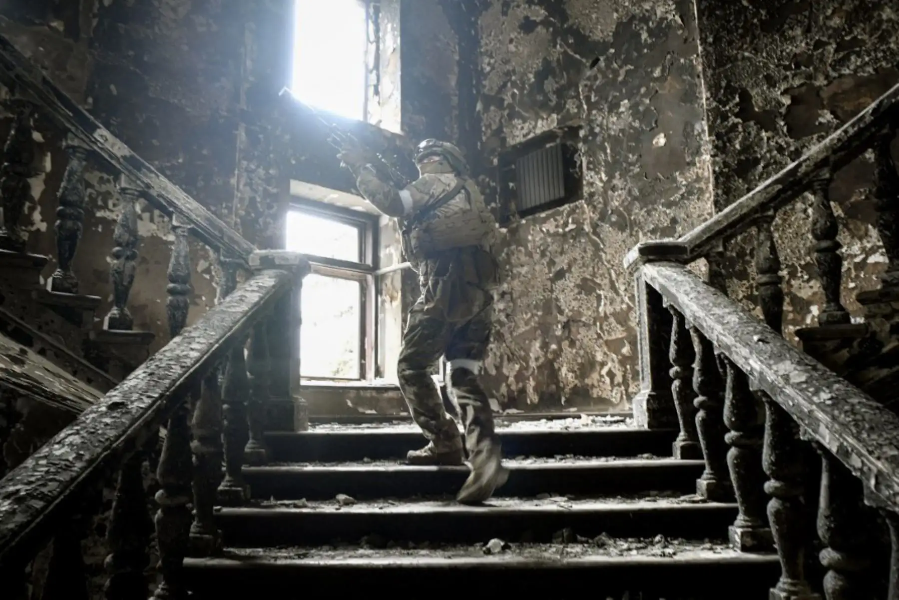 Un soldado ruso sube las escaleras en el teatro dramático de Mariupol, el 12 de abril de 2022 en Mariupol. Foto: AFP