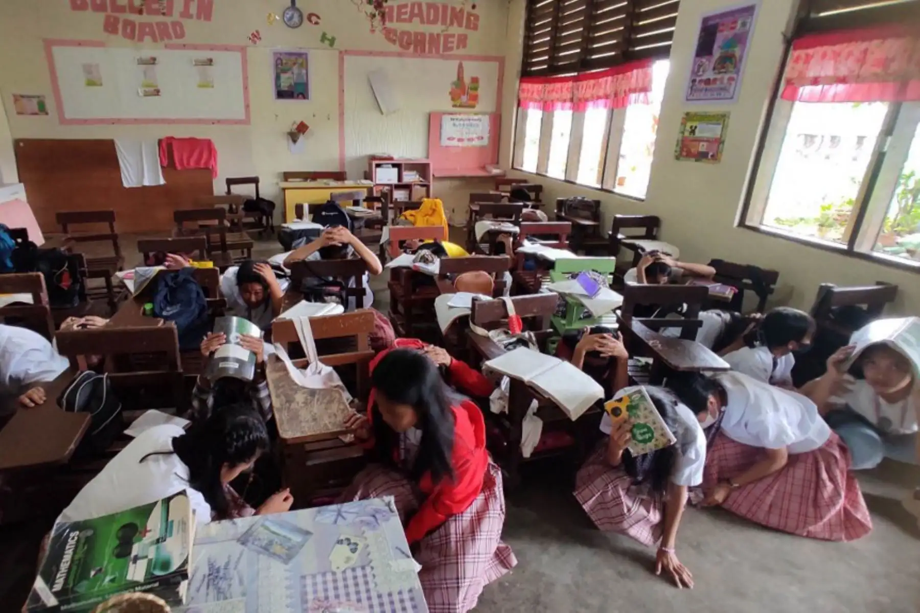 Estudiantes refugiándose dentro de su salón de clases en Mati, después de que un terremoto de magnitud 6.0 sacudiera el sur de Filipinas. Foto: AFP