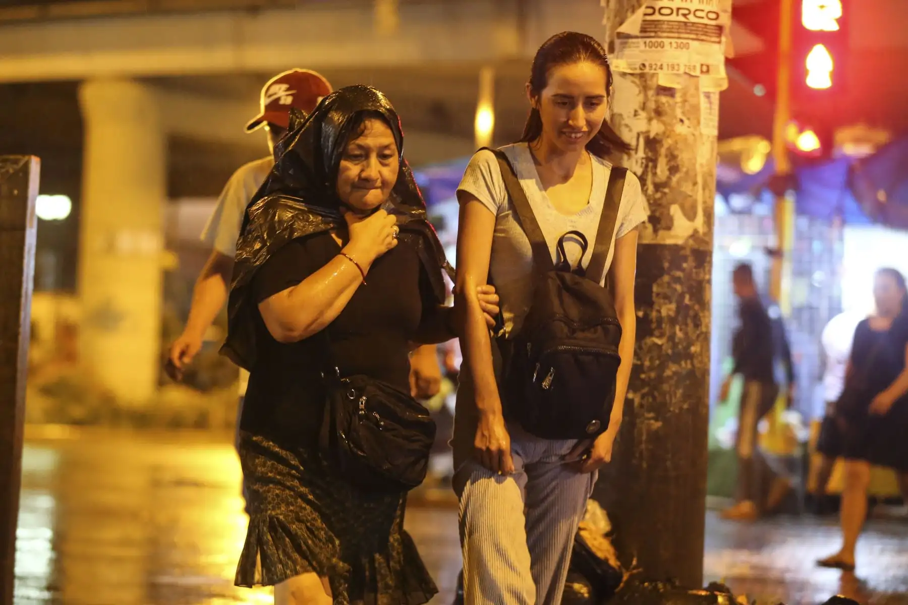 Lima entra en alerta roja debido a las intensas lluvias. Personas cruzan la calle en el Óvalo Izaguirre en Los Olivos. Foto: ANDINA/Tatiana Gamarra