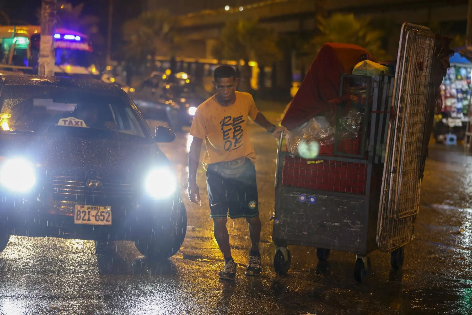Lima entra en alerta roja debido a las intensas lluvias. Hombre guarda su kiosko en el Óvalo Izaguirre en los Olivos. Foto: ANDINA/Tatiana Gamarra