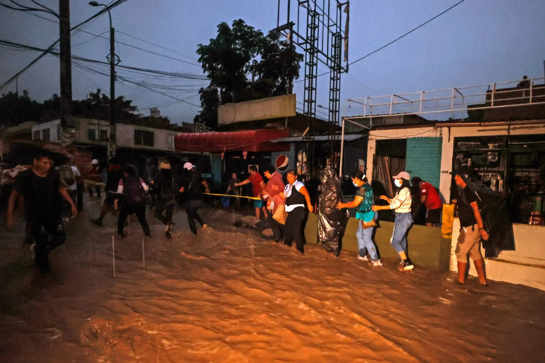 El torrente que atraviesa el distrito de Chaclacayo desde la tarde del martes, tras la activación de la quebrada Los Laureles, dificulta el retorno a casa de centenares de personas. Formando cadenas humanas y, en algunos casos, con apoyo de militares, moradores de Chosica, Ricardo Palma, Santa Eulalia y otros sectores del este de Lima buscan la manera de vadear la corriente para no verse obligados a pernoctar a la intemperie.
 Foto: ANDINA/Vidal Tarqui
