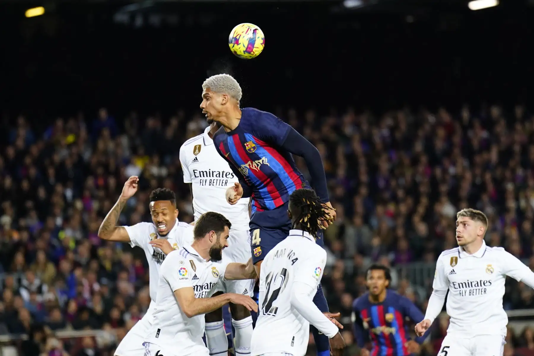 El defensa uruguayo del FC Barcelona, Ronald Araujo, intenta rematar el balón ante los defensores del Real Madrid durante el encuentro correspondiente a la jornada 26 de primera división que disputan hoy domingo en el estadio del Camp Nou, en Barcelona. 
Foto: EFE