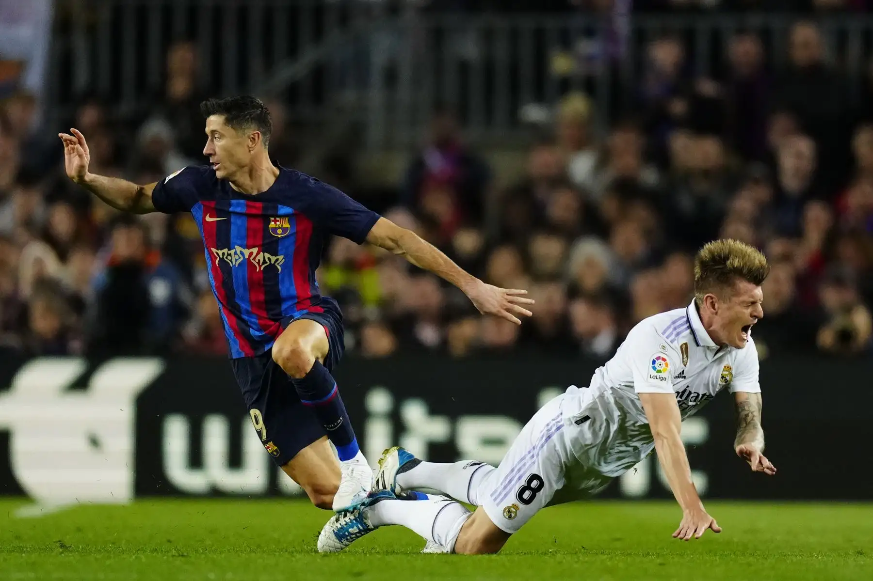 El centrocampista alemán del Real Madrid, Toni Kroos, cae ante el delantero polaco del FC Barcelona, Robert Lewandowski, durante el encuentro correspondiente a la jornada 26 de primera división que disputan hoy domingo en el estadio del Camp Nou, en Barcelona.
Foto: EFE