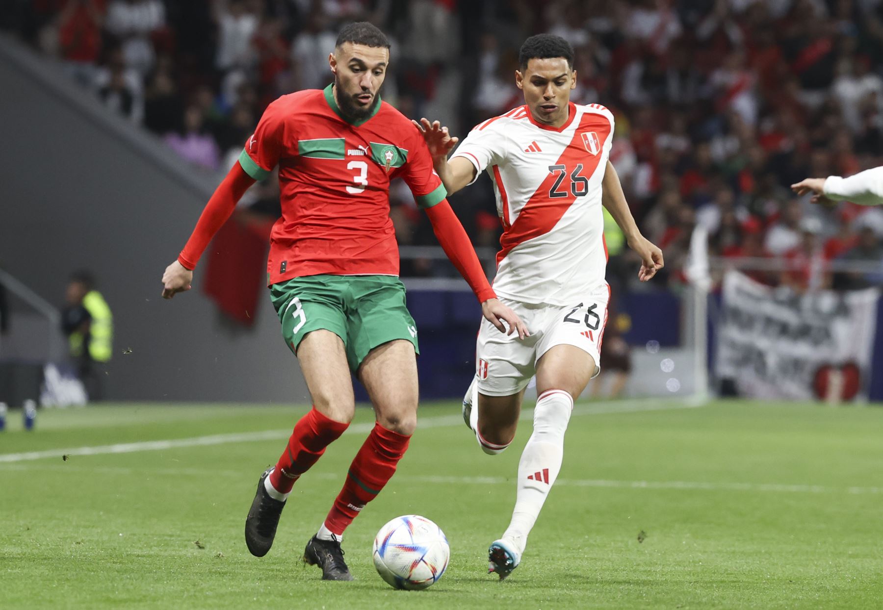 El defensa de la selección marroquí de fútbol Noussair Mazraoui  juega un balón ante Marcos López, de Perú, durante el partido amistoso que las selecciones de Marruecos y Perú disputan este martes en el estadio Civitas Metropolitano, en Madrid.
Foto: EFE