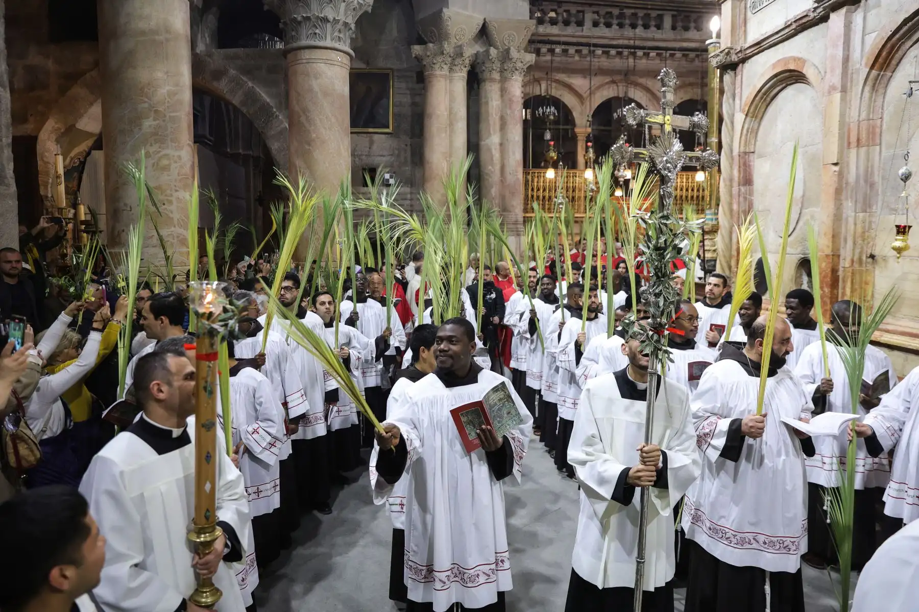 Los clérigos católicos portan ramas de palma durante la procesión del Domingo de Ramos en la Iglesia del Santo Sepulcro en la Ciudad Vieja de Jerusalén, Domingo de Ramos para los devotos católicos romanos marca simbólicamente el relato de la entrada de Jesucristo en Jerusalén, marcando el inicio de la Semana Santa. Foto: EFE