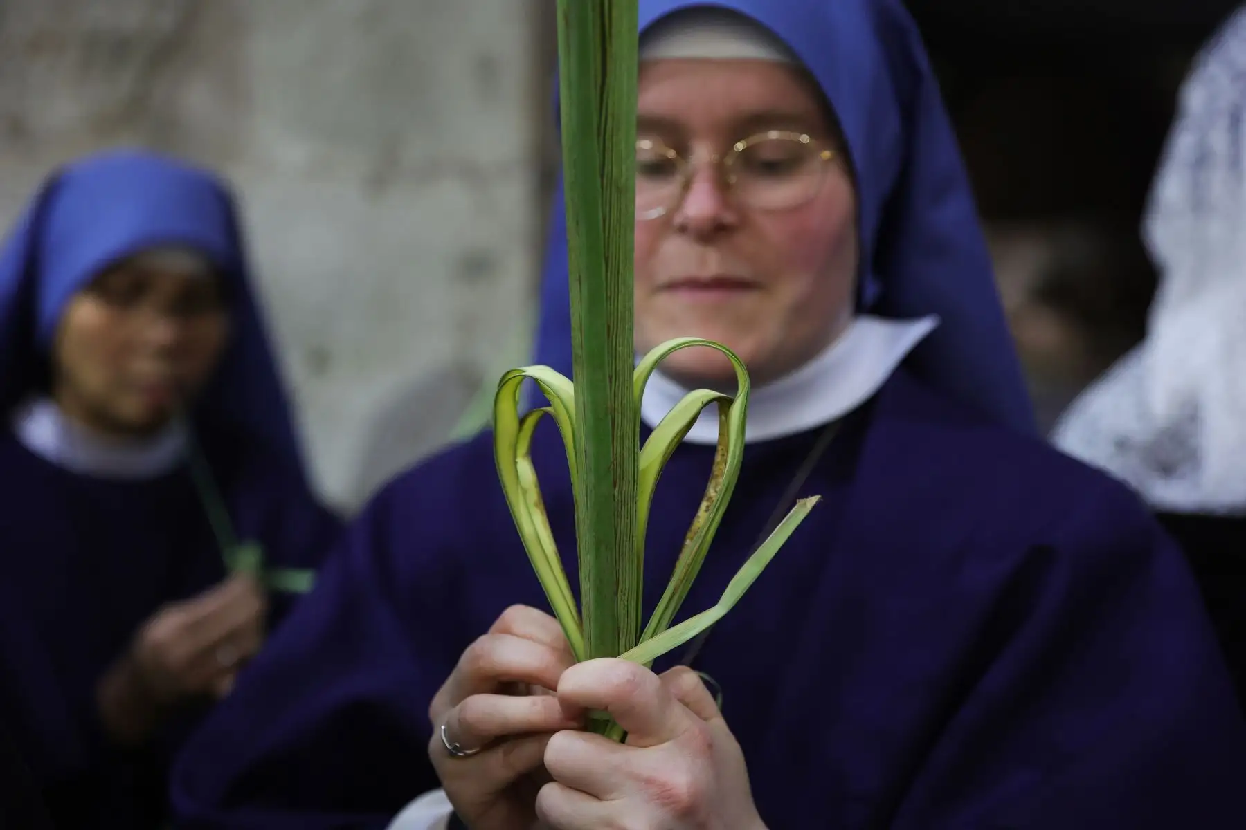 Una monja sostiene una rama de palma durante la procesión del Domingo de Ramos en la Iglesia del Santo Sepulcro en la Ciudad Vieja de Jerusalén, Domingo de Ramos para los devotos católicos romanos marca simbólicamente el relato bíblico de la entrada de Jesucristo en Jerusalén, marcando el inicio de la Semana Santa.  EFE