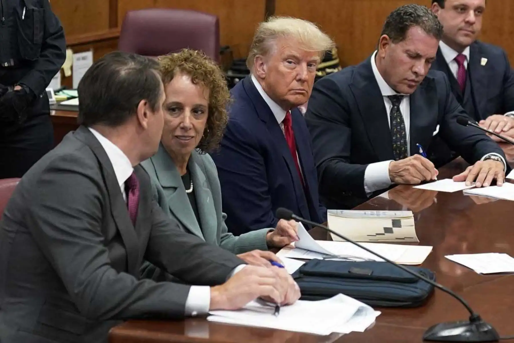 El expresidente Donald Trump se sienta en la mesa de la defensa con su equipo de defensa durante su lectura de cargos en un tribunal de Manhattan. Foto: AFP