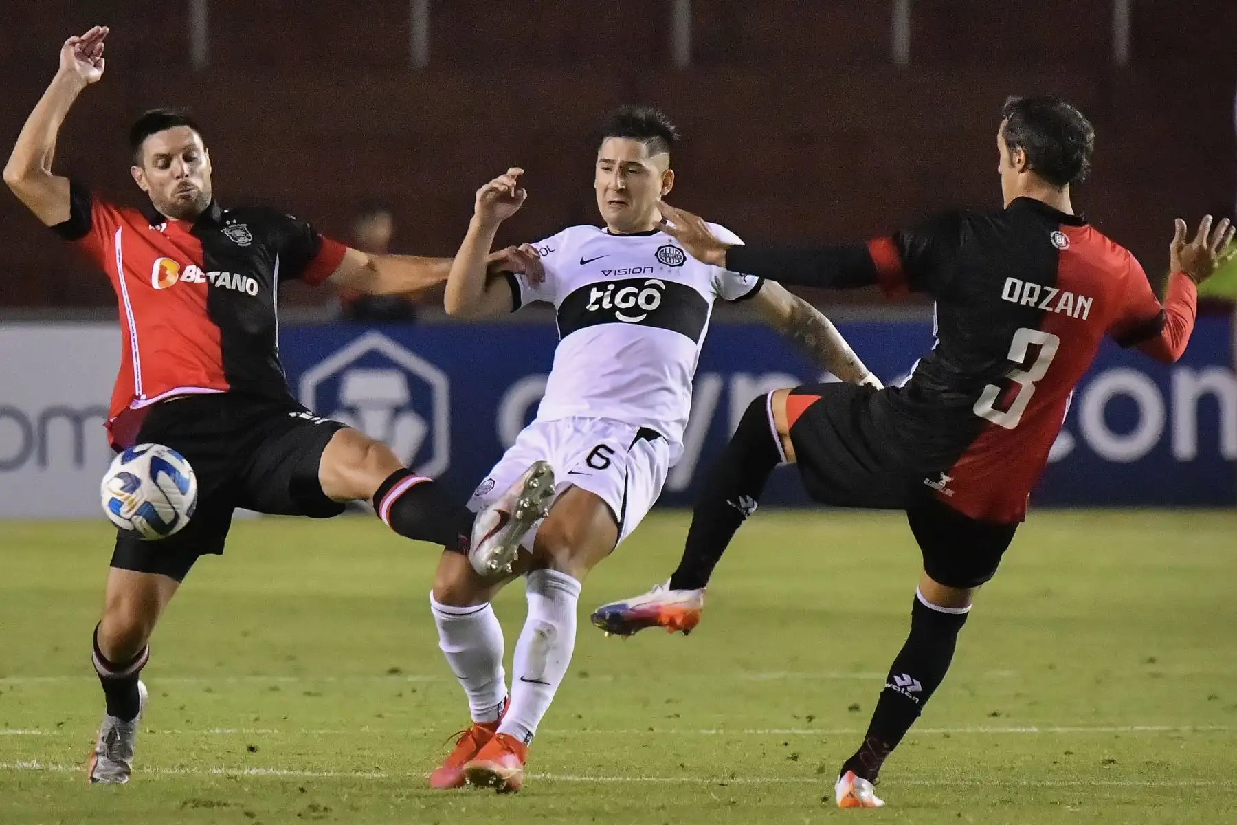 El delantero argentino de Melgar Cristian Bordacahar  y el mediocampista argentino de Melgar Horacio Orzan disputan el balón con el mediocampista de Olimpia Richard Ortiz durante el partido de ida de la fase de grupos de la Copa Libertadores entre Melgar y Olimpia, en el estadio Monumental de la UNSA en Arequipa. Foto: AFP