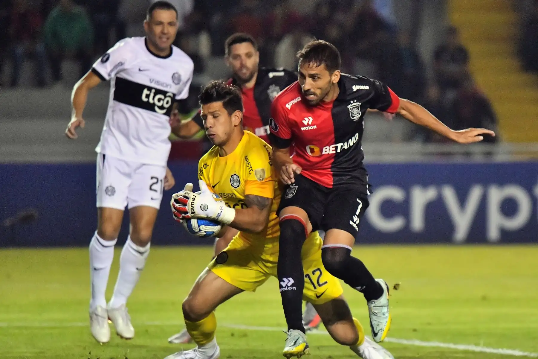 El arquero de Olimpia, Juan Espinola, agarra el balón contra la marca del delantero argentino de Melgar, Cristian Bordacahar, disputa el balón durante el partido de ida de la fase de grupos de la Copa Libertadores entre Melgar y Olimpia, en el estadio Monumental de la UNSA en Arequipa. Foto: AFP