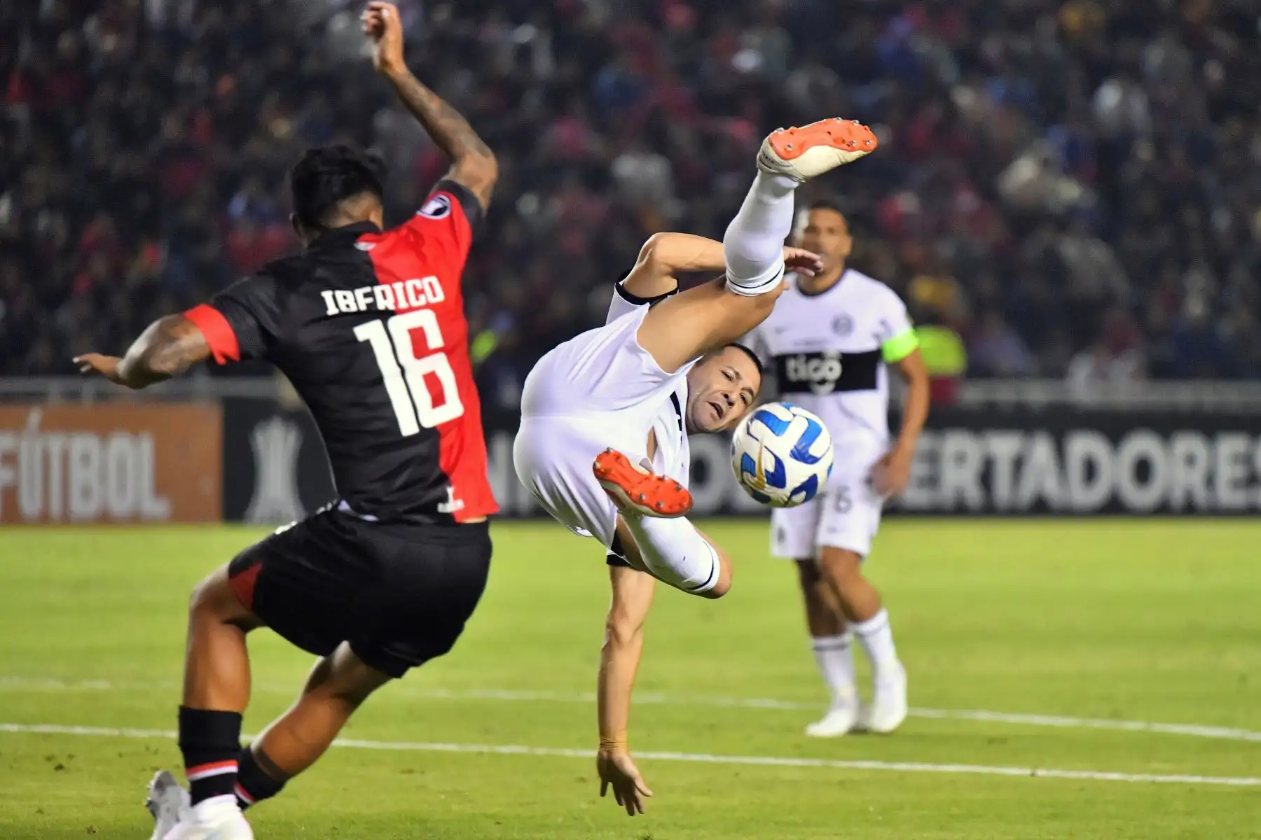 El delantero de Melgar Luis Iberico  y el defensor de Olimpia Antolín Alcaraz disputan el balón durante el partido de ida de la fase de grupos de la Copa Libertadores entre Melgar y Olimpia, en el estadio Monumental de la UNSA en Arequipa. Foto: AFP