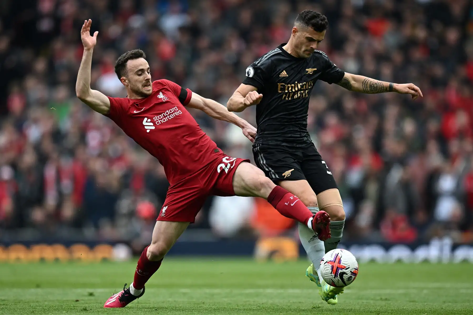El delantero portugués del Liverpool Diogo Jota  compite con el mediocampista suizo del Arsenal Granit Xhaka durante el partido de fútbol de la Premier League inglesa entre el Liverpool y el Arsenal en Anfield en Liverpool, noroeste de Inglaterra. Foto: AFP