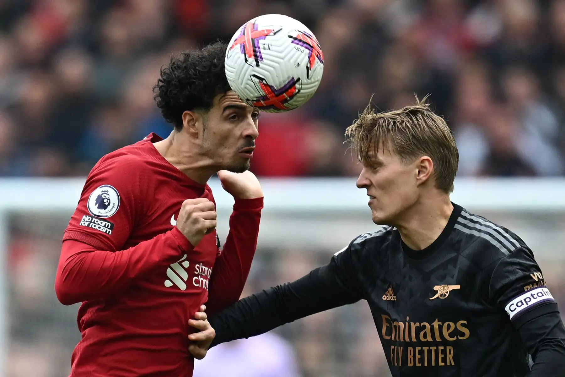 El centrocampista inglés del Liverpool Curtis Jones salta sobre el centrocampista noruego del Arsenal Martin Odegaard para encabezar el balón durante el partido de fútbol de la Premier League inglesa entre Liverpool y Arsenal en Anfield en Liverpool, noroeste de Inglaterra.Foto: ANDINA/ AFP