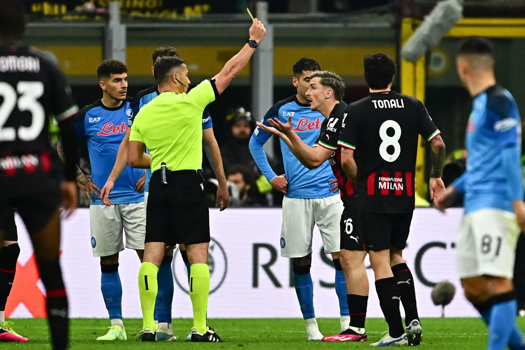 El árbitro rumano Istvan Kovacs le da una tarjeta amarilla al delantero belga del AC Milan, Alexis Saelemaekers, durante el partido de ida de los cuartos de final de la Liga de Campeones de la UEFA entre el AC Milan y el SSC Napoli. Foto: AFP