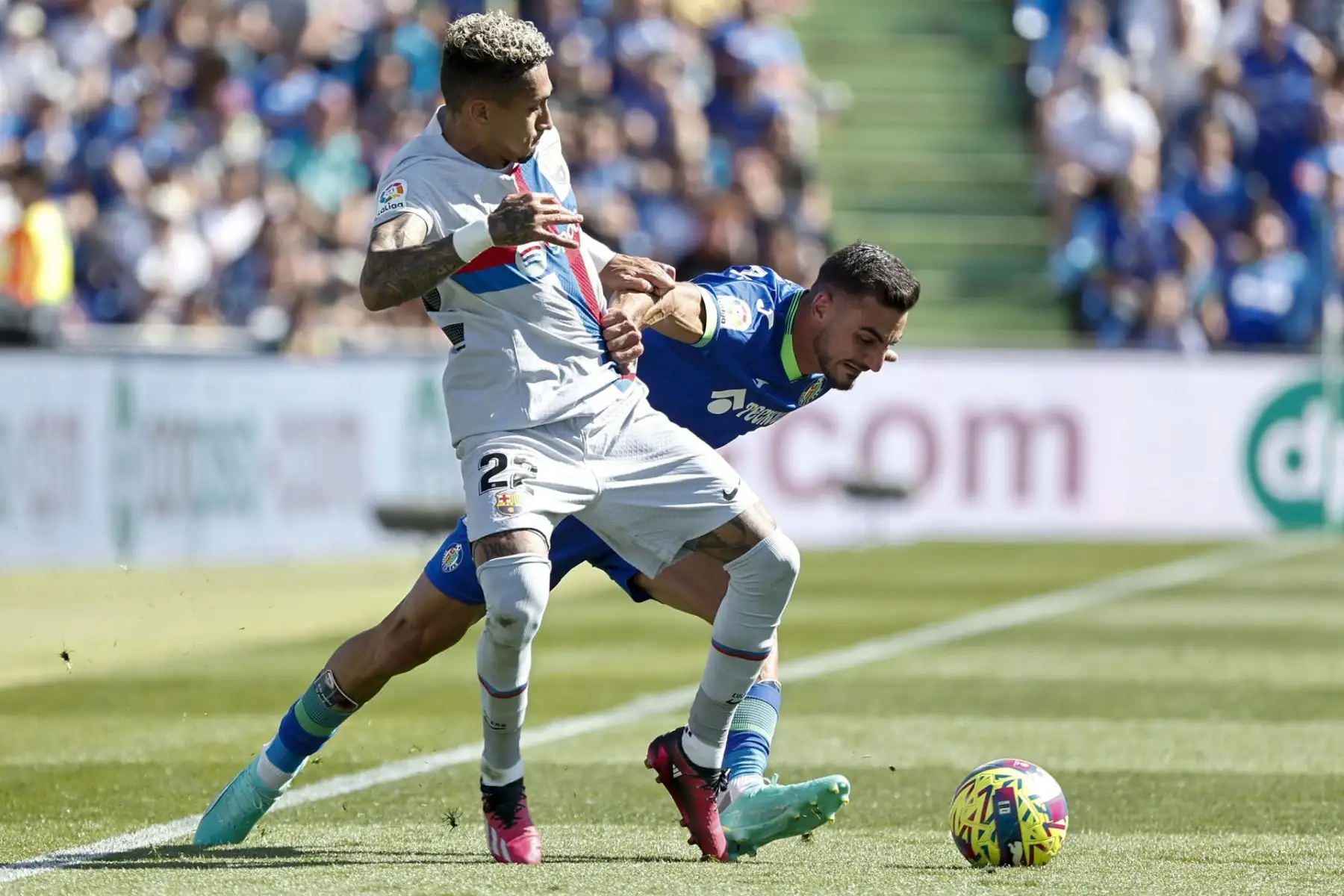 El delantero brasileño del Barcelona Raphinha (i) controla el balón durante el partido de LaLiga entre el Getafe y el Barcelona, este domingo en el Coliseo Alfonso Pérez.
Foto: EFE