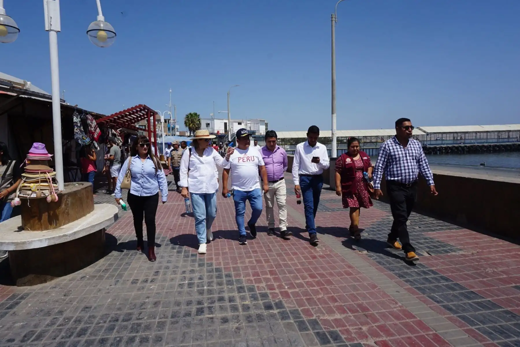 La viceministra de Turismo, Madeleine Burns (con sombrero), y el alcalde distrital de Paracas, Omar Bohórquez (con gorra), recorren el malecón turístico El Chaco. Foto: Cortesía.