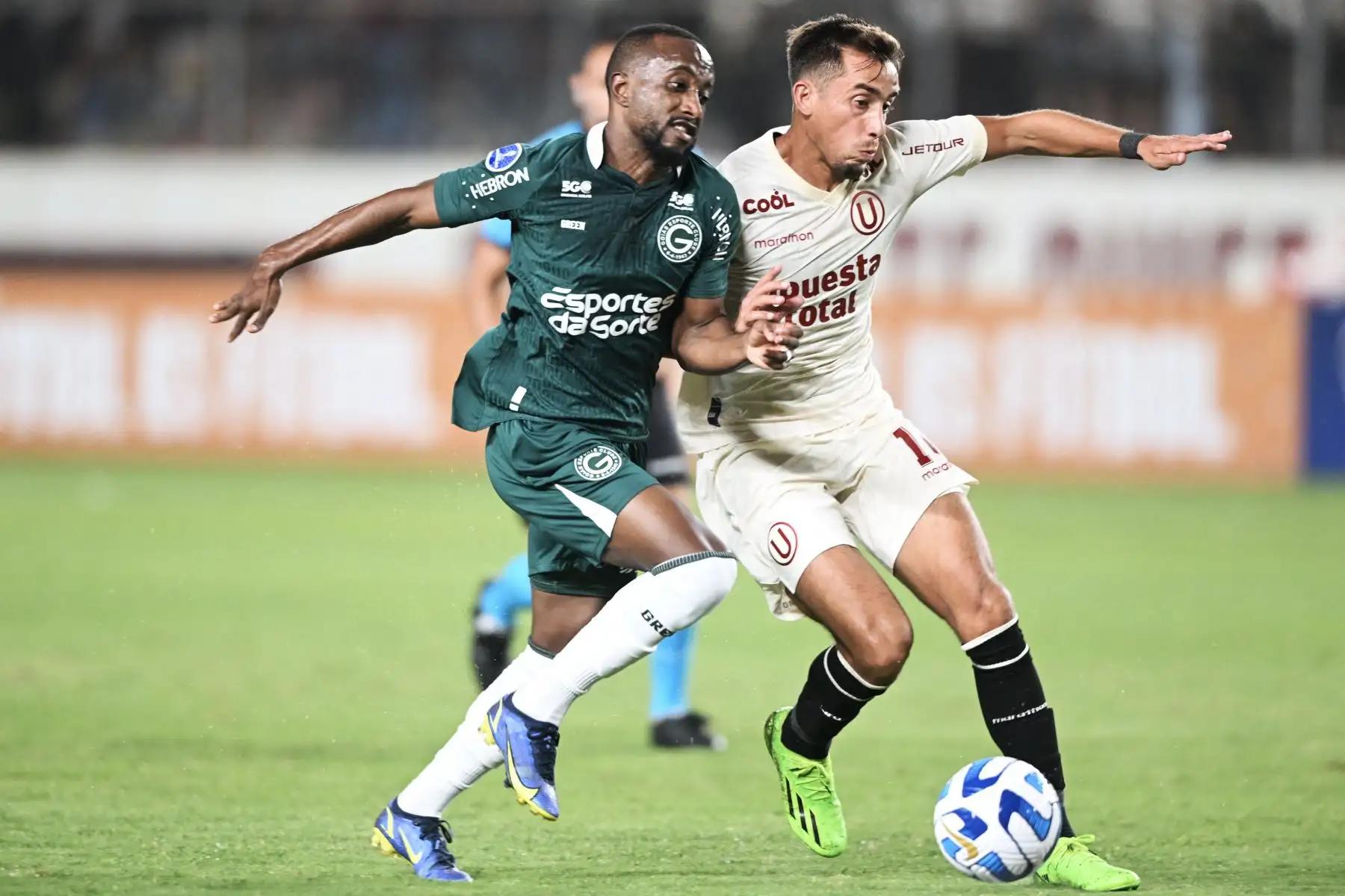 El delantero del Goiás, Diego, y el mediocampista argentino del Universitario, Martín Pérez, compiten por el balón durante el partido de ida de la fase de grupos de la Copa Sudamericana entre Universitario y Goiás en el estadio Monumental de Lima el 20 de abril de 2023.
Foto: AFP
