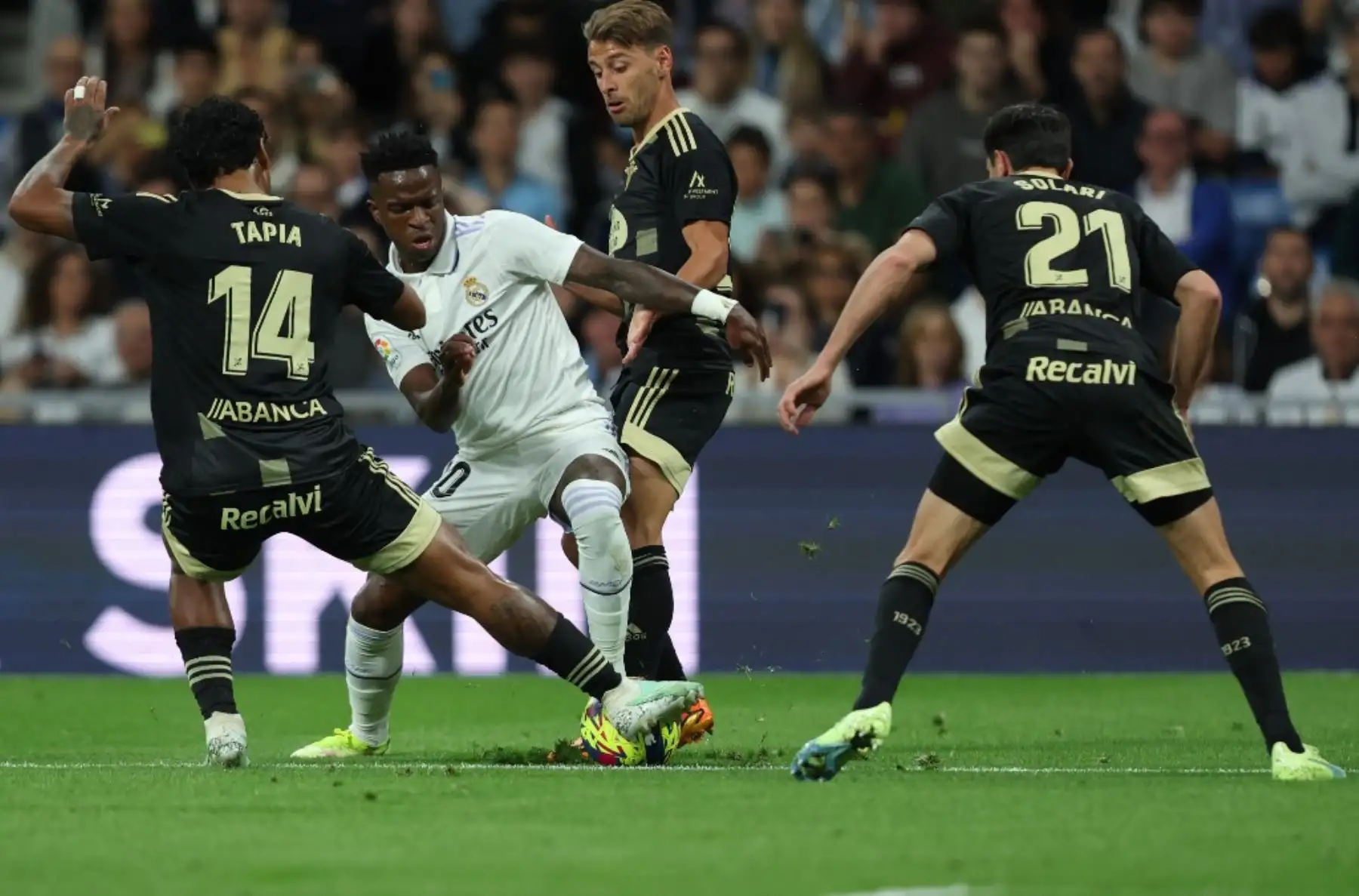 El delantero brasileño del Real Madrid Vinicius Junior (2L) compite con el centrocampista peruano del Celta de Vigo Renato Tapia (L) y el centrocampista argentino del Celta de Vigo Augusto Solari (R) durante el partido de fútbol de la liga española entre el Real Madrid CF y el RC Celta de Vigo en el estadio Santiago Bernabéu de Madrid el 22 de abril de 2023. Foto: AFP