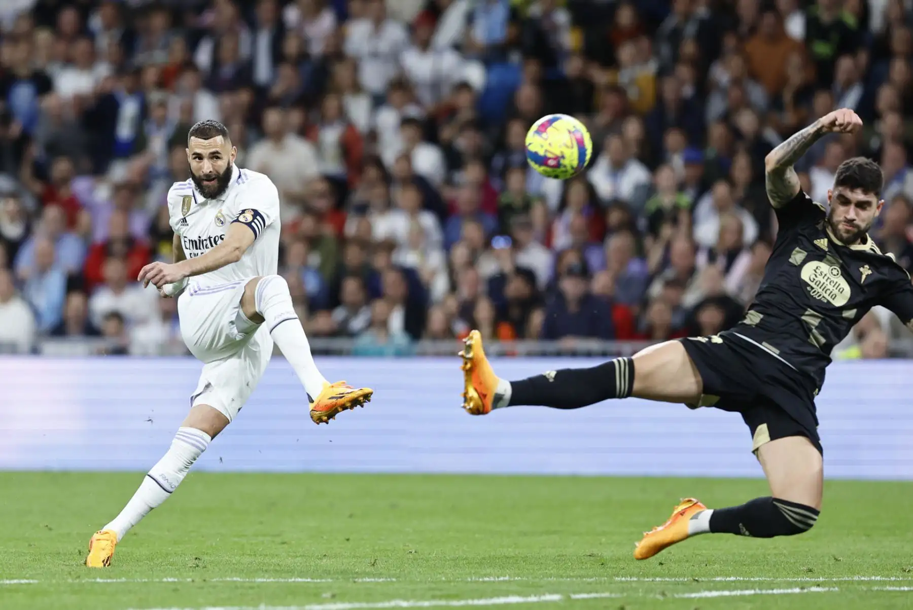 El delantero francés del Real Madrid, Karim Benzema (i), remata ante el defensa del Celta, Javi Galán, durante el partido de la jornada 30 de Liga que Real Madrid y Celta de Vigo disputan este sábado en el estadio Santiago Bernabéu, en Madrid. Foto: EFE