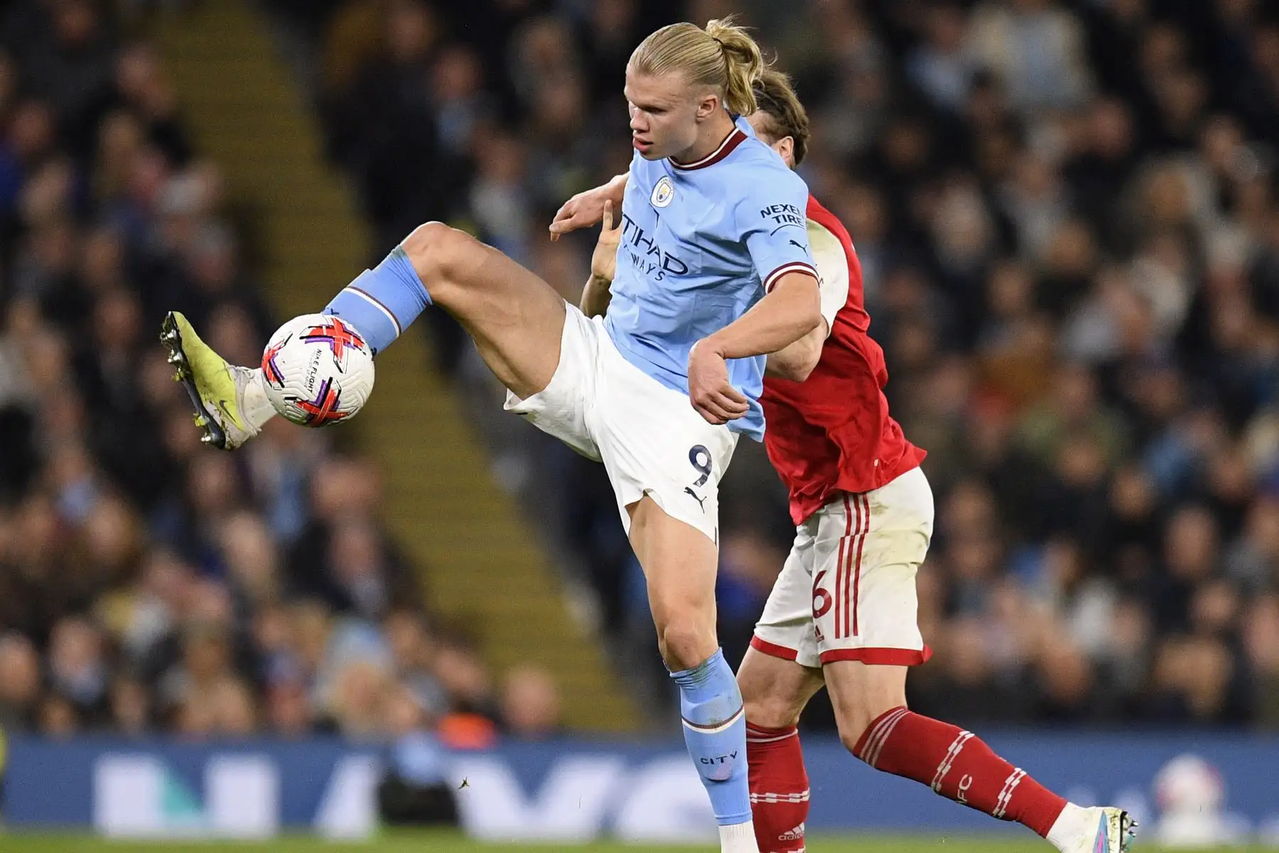 El defensor inglés del Arsenal, Rob Holding, compite con el delantero noruego del Manchester City, Erling Haaland, durante el partido de fútbol de la Premier League inglesa entre el Manchester City y el Arsenal. Foto:ANDINA/ AFP