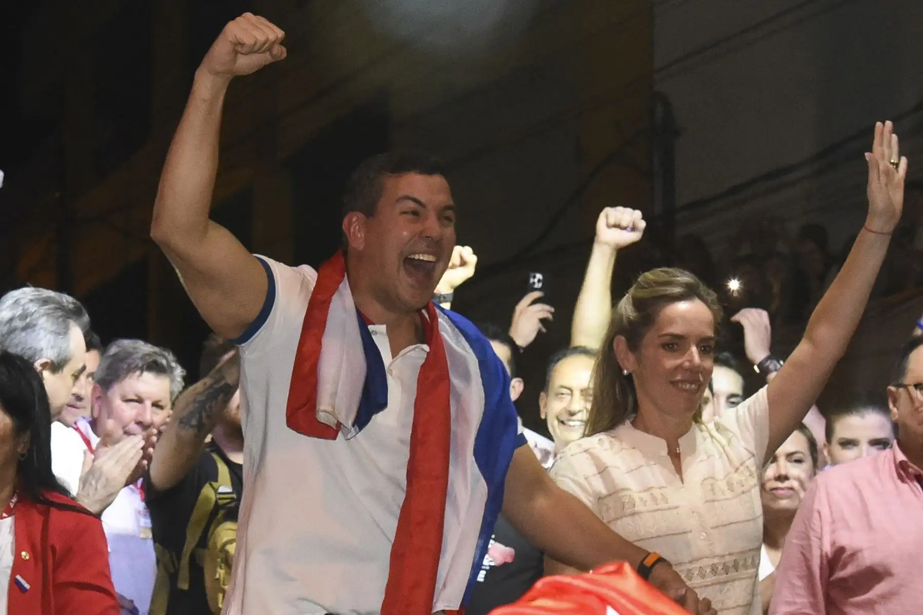 El candidato presidencial paraguayo por el Partido Colorado, Santiago Peña, celebra con simpatizantes acompañado de su esposa, Leticia Ocampos de Pea, tras ganar las elecciones presidenciales en Asunción el 30 de abril de 2023. Los paraguayos eligieron el domingo a un presidente del derechista Partido Colorado, en el poder desde hace casi ocho décadas, rechazando a un aspirante de centroizquierda que había arremetido contra la corrupción institucional. Foto: AFP