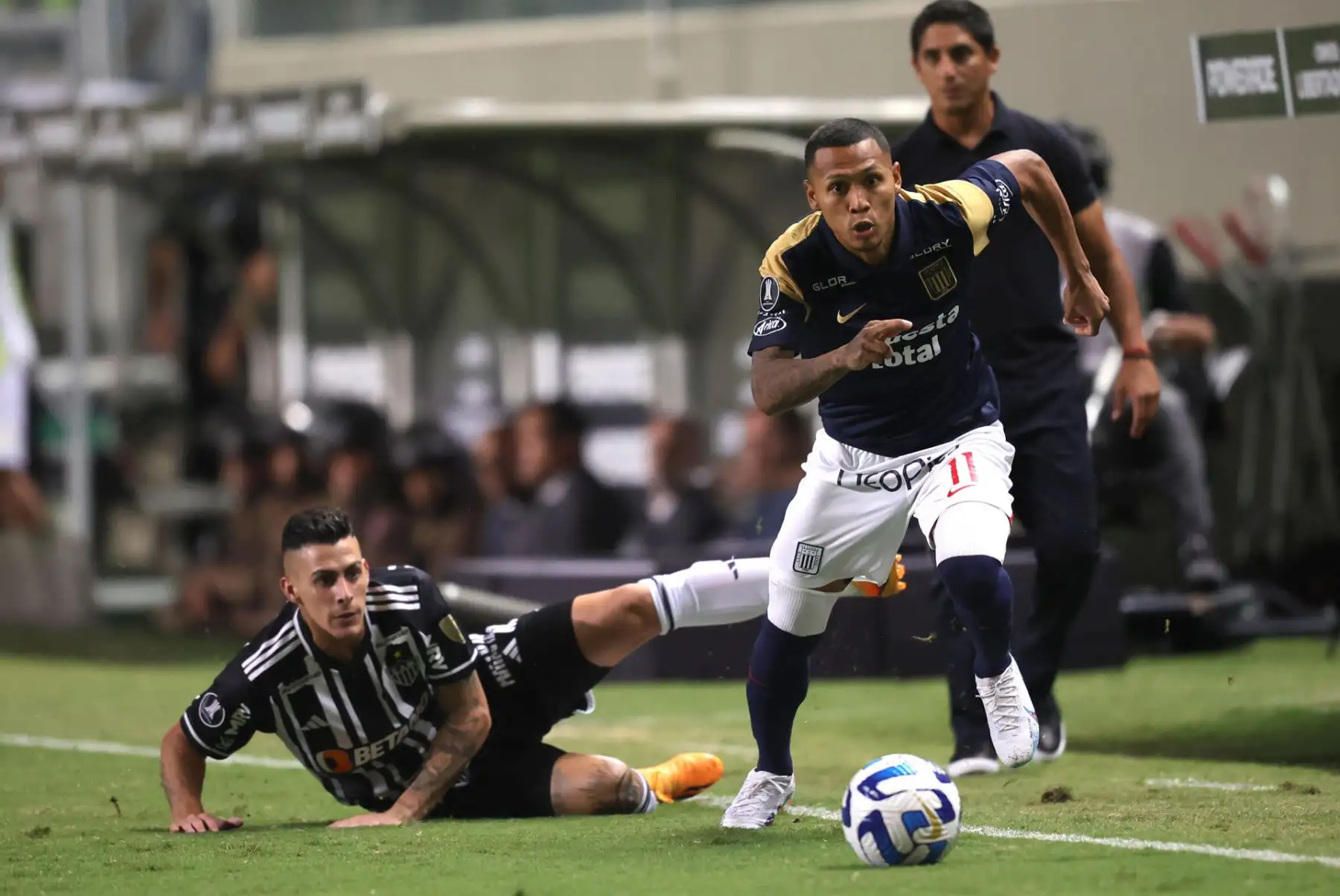 Cristian Pavón (i) de Atlético Mineiro disputa el balón con Ricardo Lagos Puyén de Alianza Lima, hoy, durante el partido de la fase de grupos de la Copa Libertadores entre Atlético Mineiro de Brasil y el Club Alianza Lima peruano hoy, en el estadio Raimundo Sampaio, en Belo Horizonte (Brasil). Foto: EFE