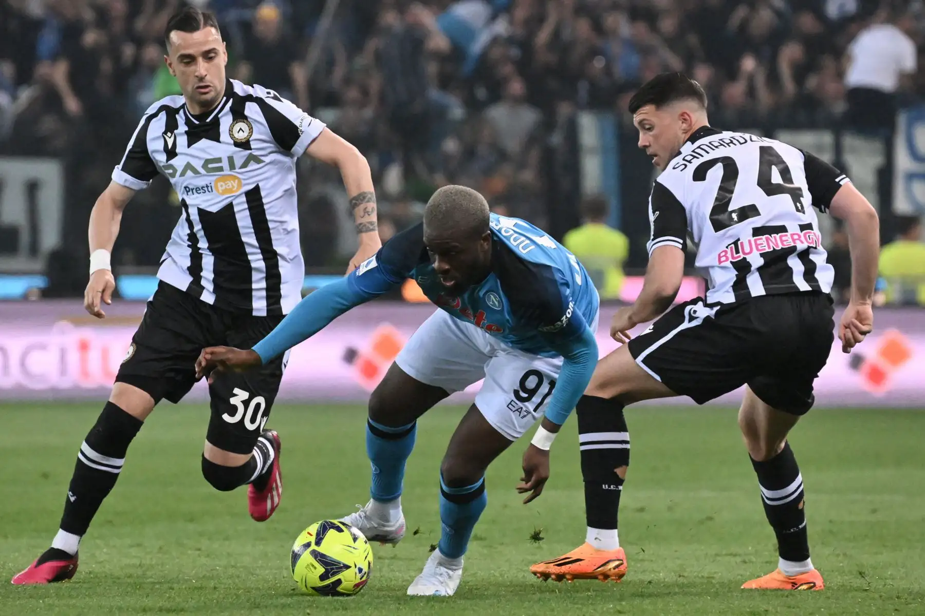 El mediocampista francés del Napoli Tanguy Ndombele desafía al delantero macedonio del Udinese Ilija Nestorovski  y al mediocampista alemán del Udinese Lazar Samardzic durante el partido de fútbol de la Serie A italiana entre el Udinese y el Napoli. Foto : ANDINA/AFP