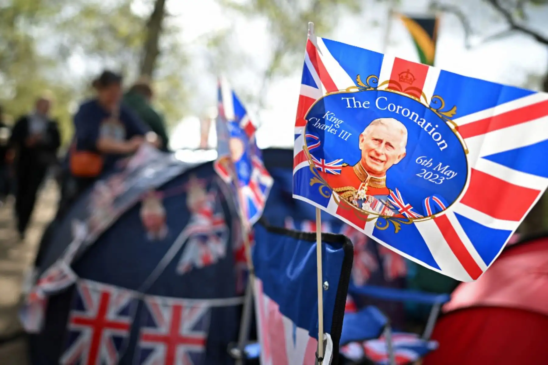 Una bandera que muestra al rey Carlos III de Gran Bretaña ondea en la brisa mientras los fanáticos reales acampan en The Mall en la ruta de la procesión cerca del Palacio de Buckingham en el centro de Londres, antes del fin de semana de coronación. Foto: AFP