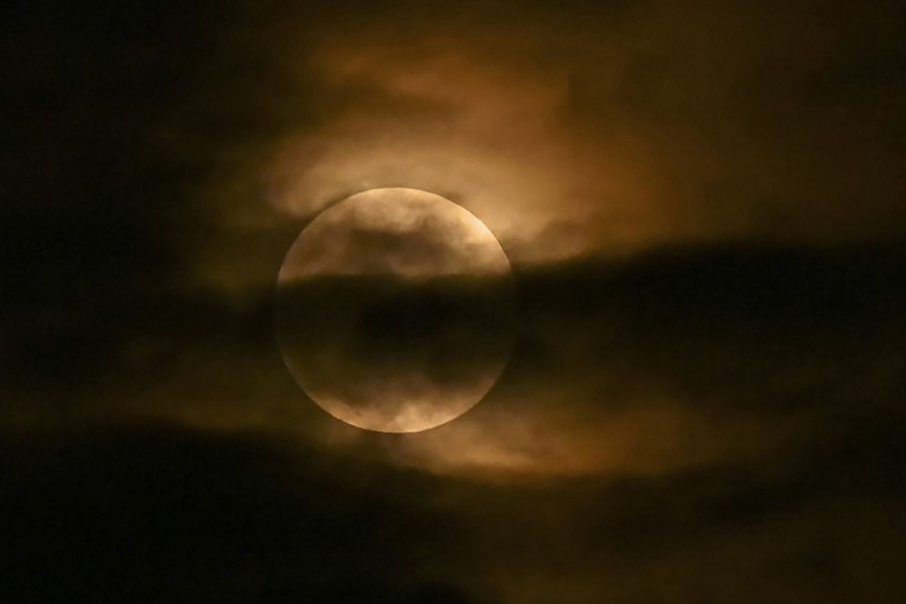 La luna se ve a través de las nubes durante un eclipse lunar parcial en Srinagar el 5 de mayo de 2023. Foto: AFP