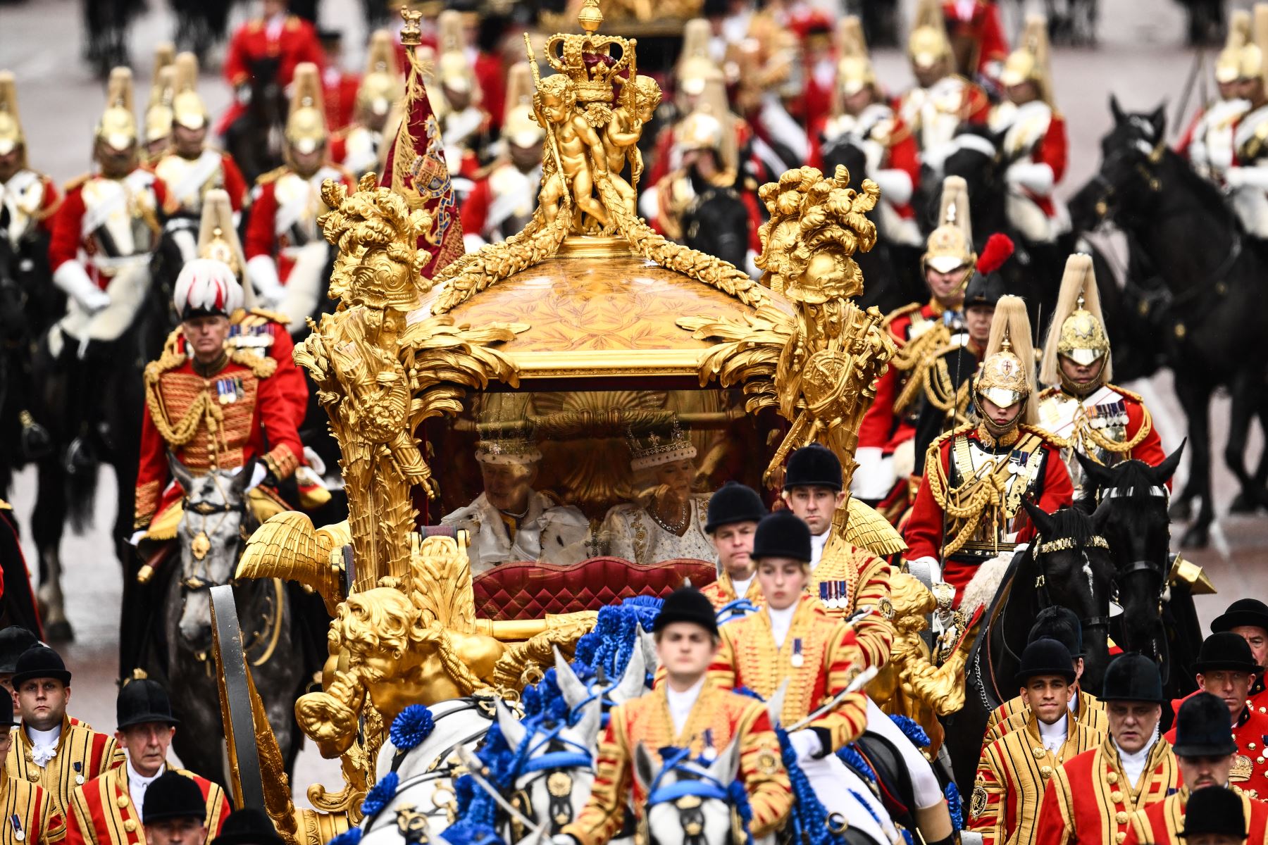 El rey Carlos III de Gran Bretaña y la reina Camila de Gran Bretaña viajan en el Gold State Coach, de regreso al Palacio de Buckingham desde la Abadía de Westminster en el centro de Londres el 6 de mayo de 2023, después de sus coronaciones. La coronación es la primera en Gran Bretaña en 70 años, y solo la segunda en la historia en ser televisada. Foto: AFP