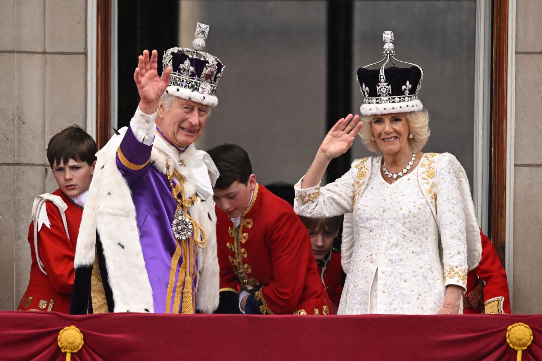 El rey Carlos III de Gran Bretaña con la corona del estado imperial y la reina Camila de Gran Bretaña con una versión modificada de la corona de la reina María saludan desde el balcón del Palacio de Buckingham después de ver el vuelo de la Royal Air Force en el centro de Londres el 6 de mayo de 2023, después de sus coronaciones. La coronación es la primera en Gran Bretaña en 70 años, y solo la segunda en la historia en ser televisada. Carlos será el monarca reinante número 40 en ser coronado en la iglesia d