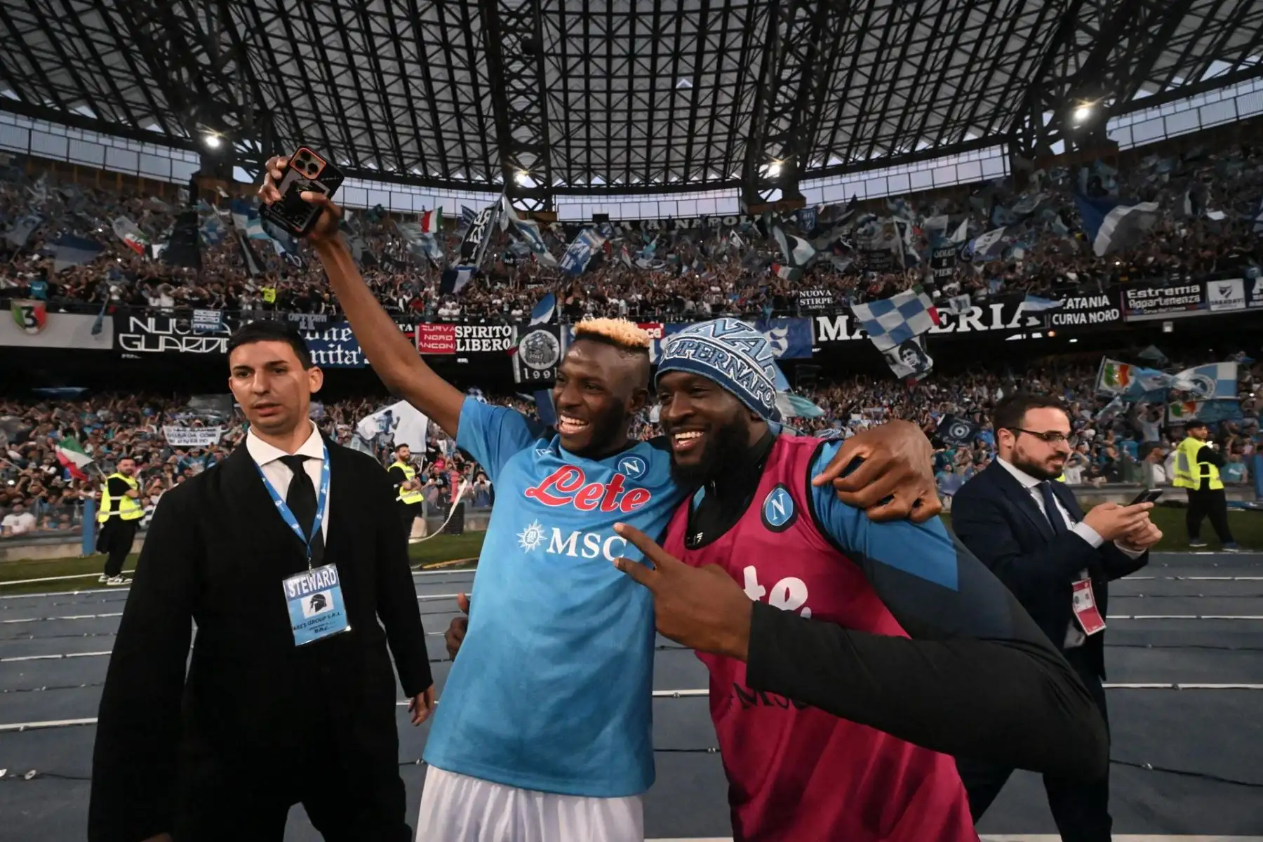Victor Osimhen (L) de Napoli celebra con fanáticos y compañeros de equipo la tercera victoria del título de liga de su equipo, el Scudetto, después de ganar el partido de fútbol de la Serie A entre SSC Napoli y ACF Fiorentina en Nápoles, Italia, 07 de mayo de 2023.
Foto: AFP