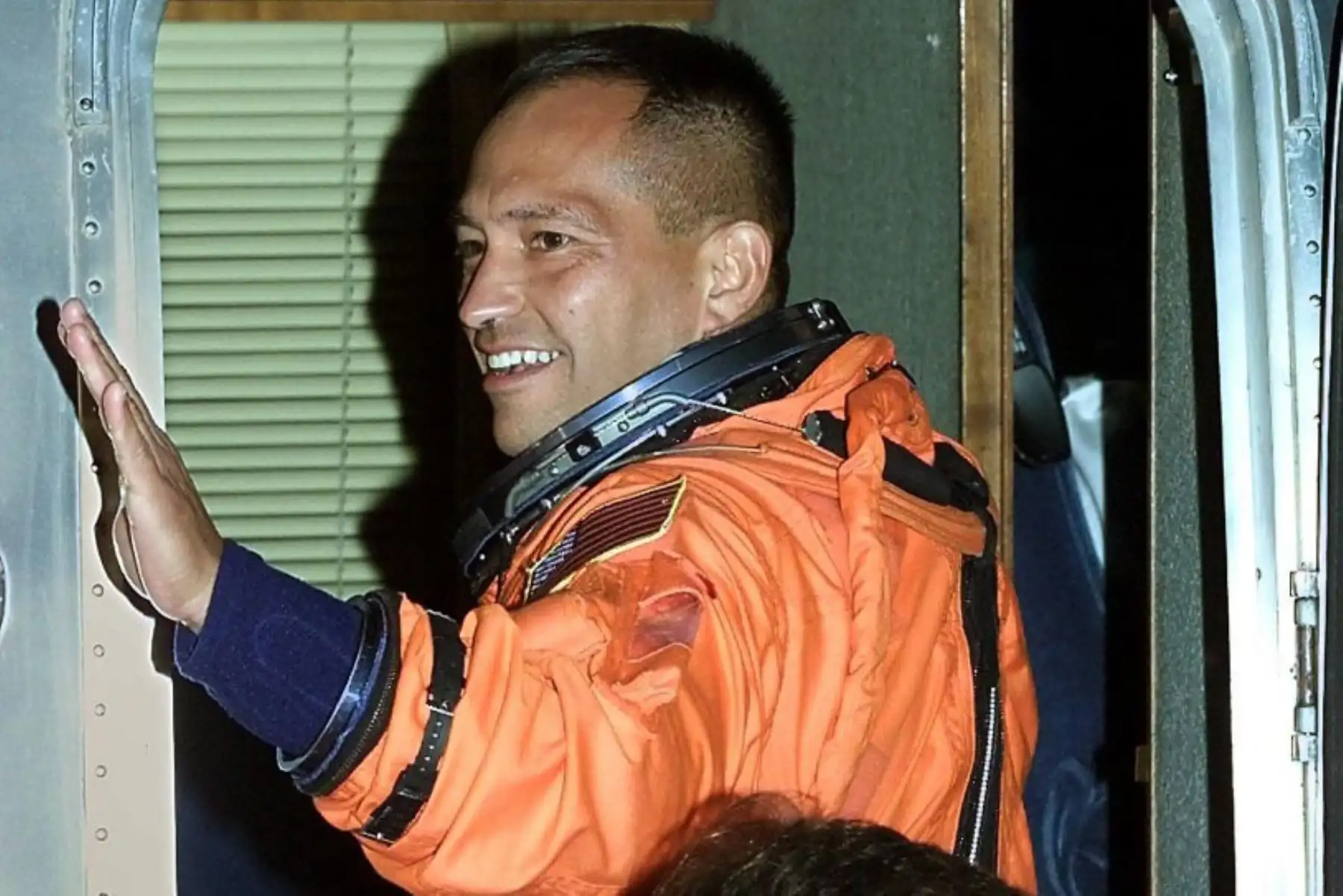 El especialista de misión del transbordador espacial S Carlos I. Noriega, saluda mientras abordan un autobús que los llevará a la plataforma de lanzamiento 39-B y al transbordador Endeavour 30 de noviembre de 2000 en el Centro Espacial Kennedy, Florida. Foto: AFP