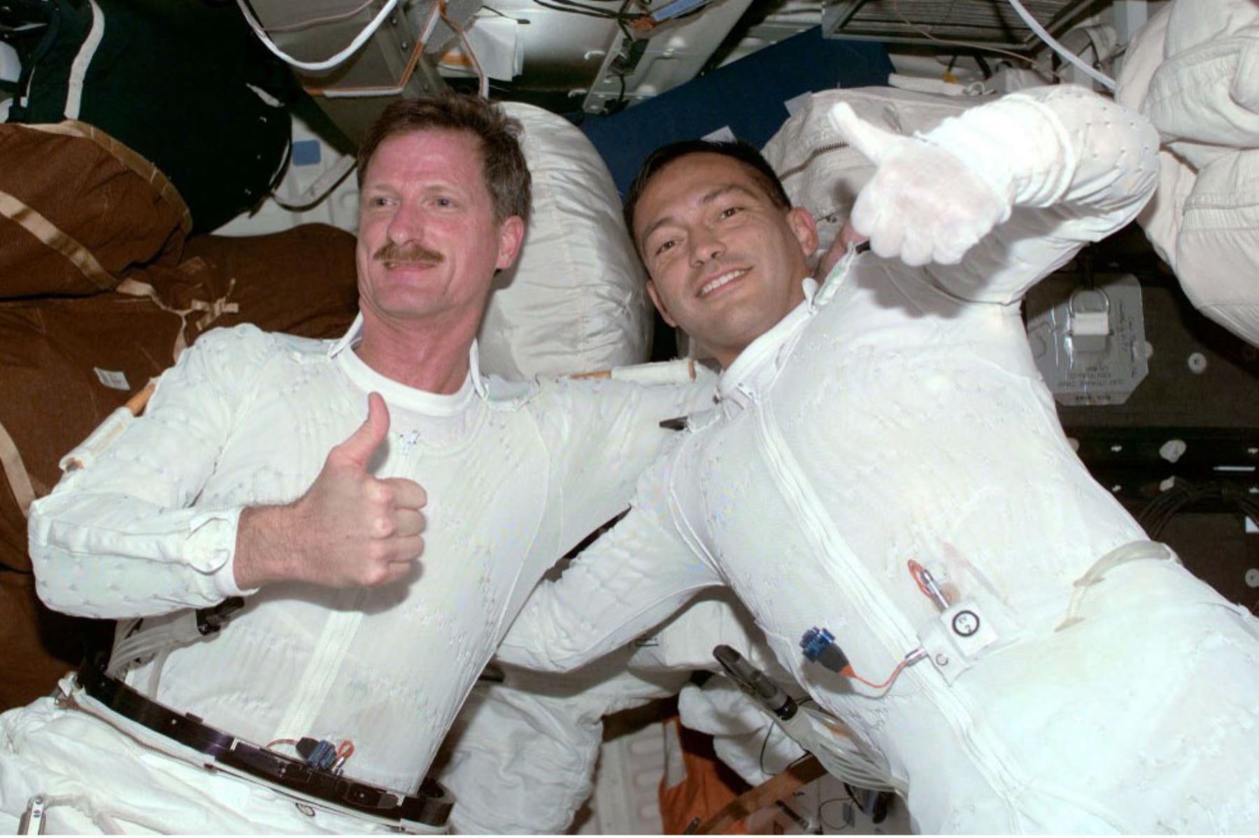 Los astronautas del transbordador espacial estadounidense Endeavour Joe Tanner de los EE. UU. y el peruano Carlos Noriega de los EE. UU. levantan el pulgar, 07 de diciembre de 2000, a bordo de la Estación Espacial Internacional después de su tercera y última caminata espacial. Foto: AFP
