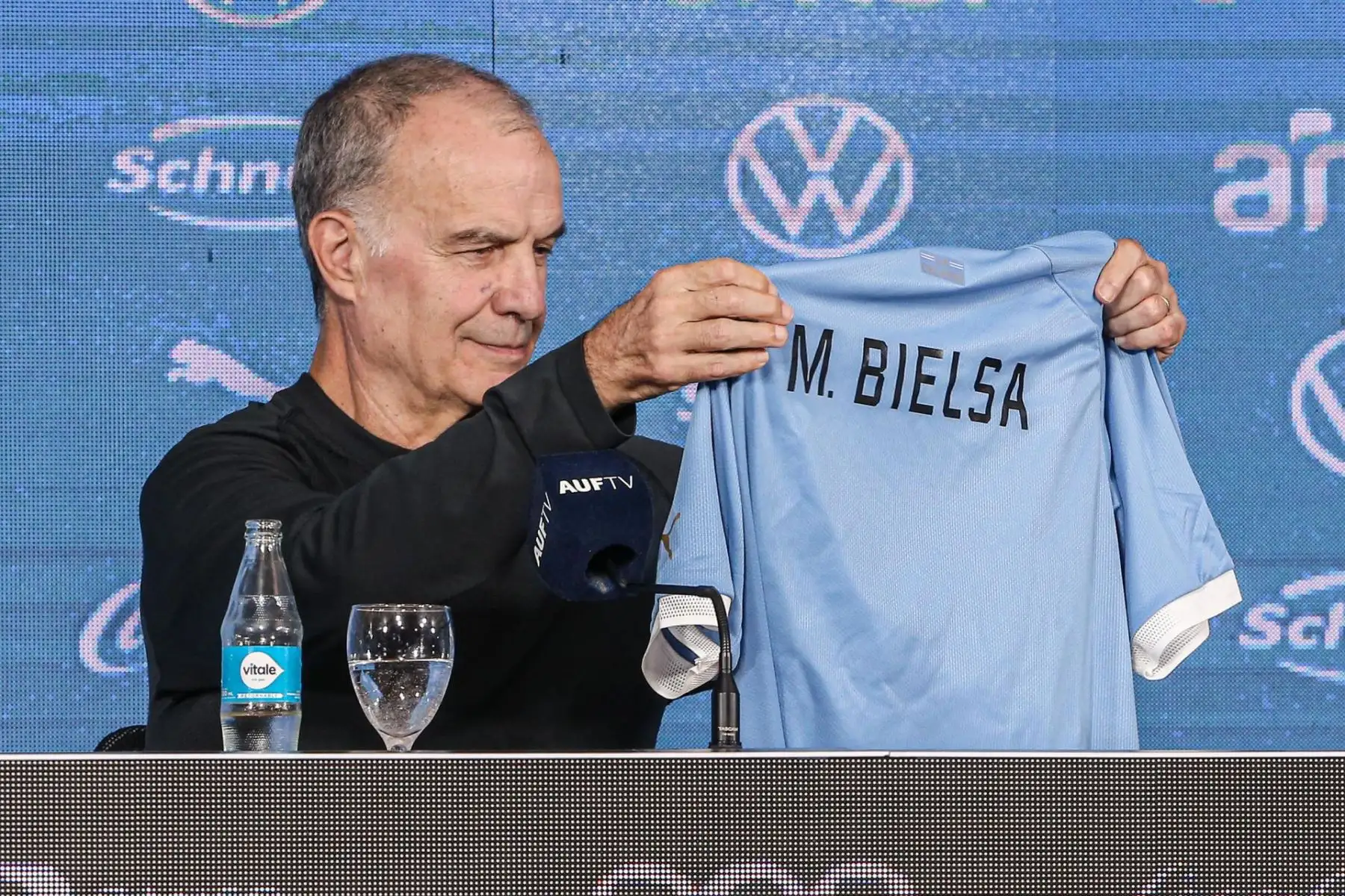 El nuevo entrenador de la selección uruguaya, Marcelo Bielsa, recibe una camiseta de la selección durante su presentación oficial hoy en el Estadio Centenario en Montevideo (Uruguay). El argentino Marcelo Bielsa aseguró este miércoles durante su presentación como nuevo seleccionador de Uruguay que no tuvieron que convencerlo para aceptar ese cargo y remarcó que los jugadores y los ciudadanos de ese país fueron "fundamentales" para tomar la decisión. 
Foto: EFE