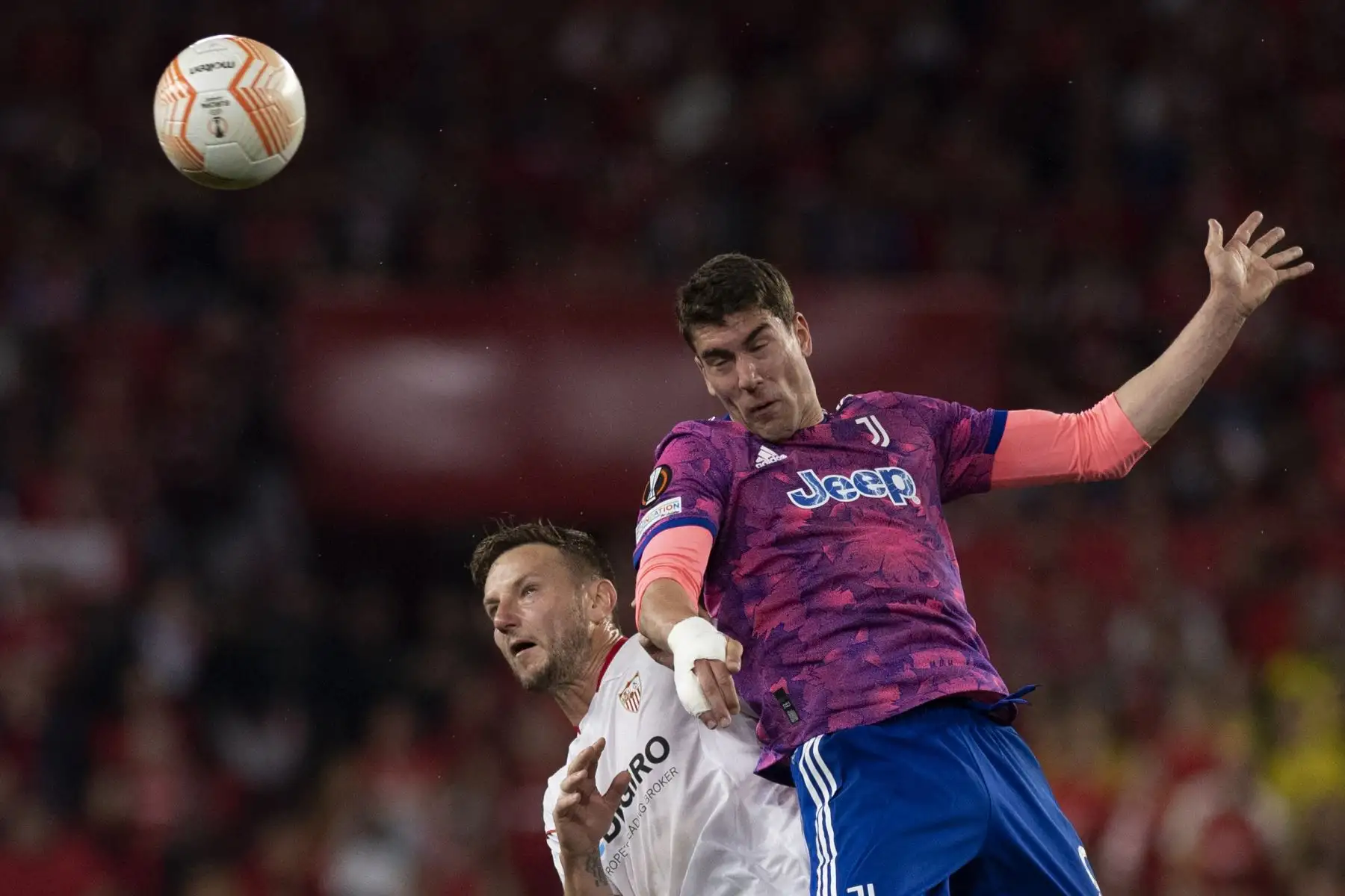 El delantero serbio de la Juventus, Dusan Vlahovic, encabeza el balón junto al centrocampista croata del Sevilla, Ivan Rakitic, durante el partido de vuelta de la semifinal de la Liga Europea de la UEFA entre el Sevilla FC y la Juventus. Foto:ANDINA/ AFP