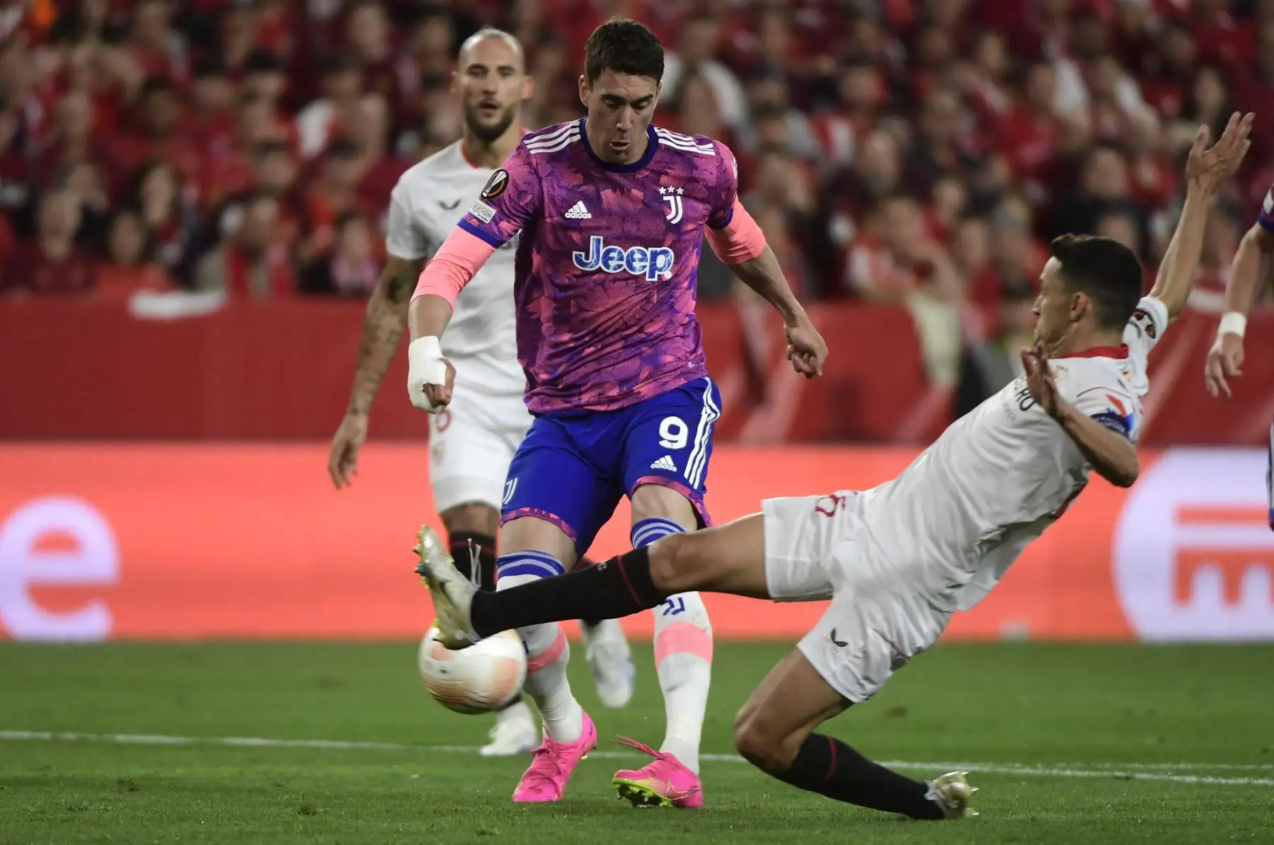 El delantero serbio de la Juventus, Dusan Vlahovic, dispara y marca el gol de apertura a pesar de la entrada del centrocampista español del Sevilla Jesús Navas durante el partido de vuelta de la semifinal de la Liga Europea de la UEFA entre el Sevilla FC y la Juventus. Foto: AFP