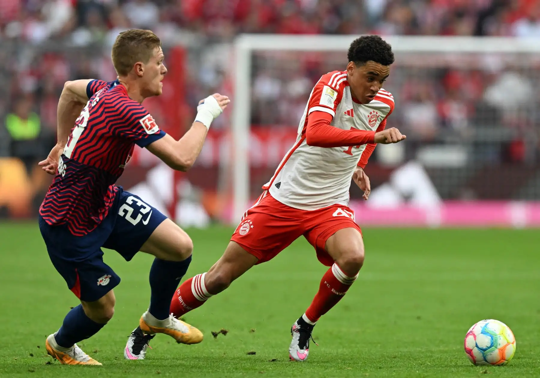 El centrocampista del Bayern Munich Jamal Musiala y el defensor de Leipzig Marcel Halstenberg compiten por el balón durante el partido de fútbol de la primera división alemana de la Bundesliga entre el FC Bayern Munich y el RB Leipzig en Munich, al sur de Alemania. Foto: AFP