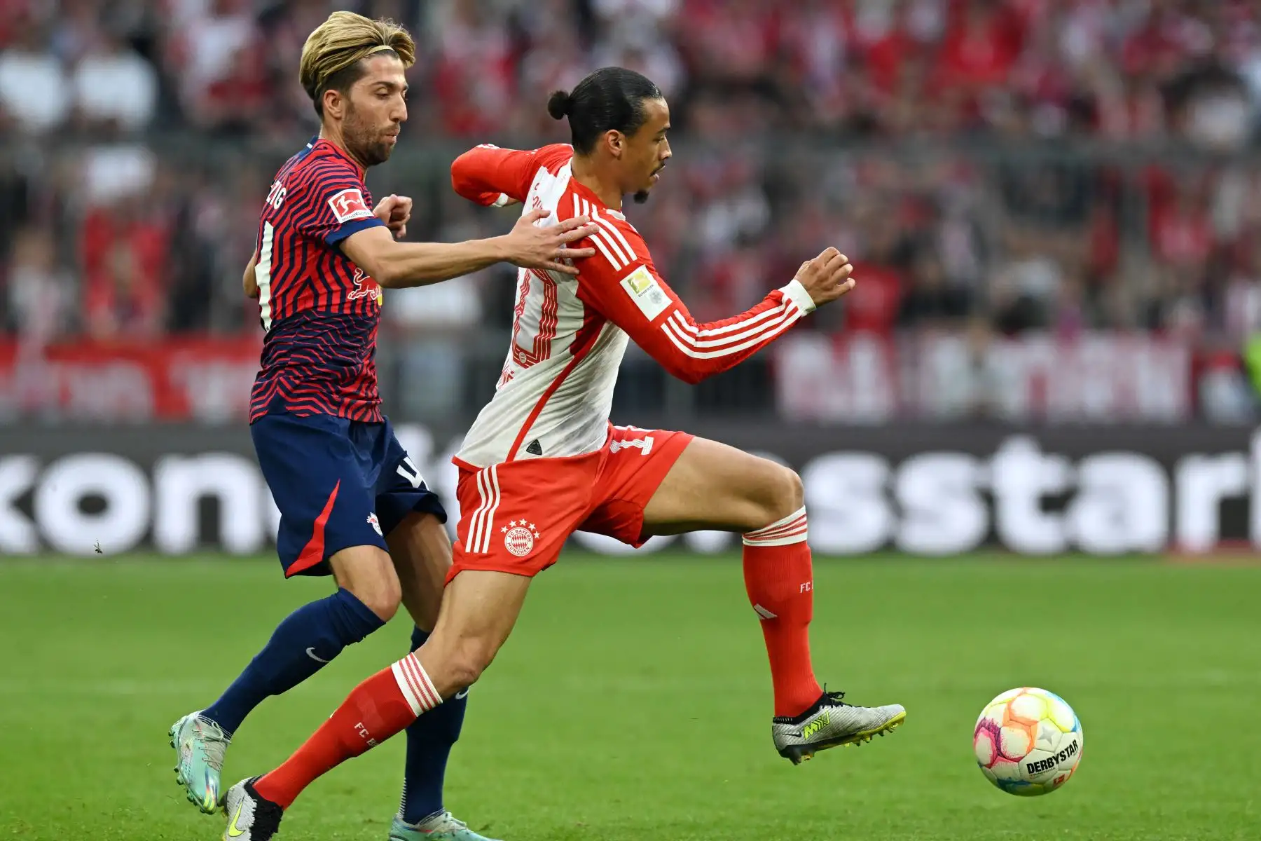 El centrocampista del Bayern de Múnich, Leroy Sane, y el centrocampista esloveno de Leipzig, Kevin Kampl, compiten por el balón durante el partido de fútbol de la primera división de la Bundesliga alemana entre el FC Bayern de Múnich y el RB Leipzig en Múnich, en el sur de Alemania. Foto: ANDINA/ AFP