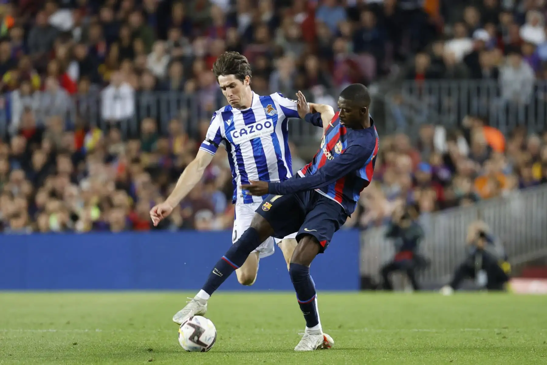 El delantero francés del FC Barcelona Ousmane Dembélé (d) lucha con Aritz Elustondo, de la Real Sociedad, durante el partido correspondiente a la jornada 35 de LaLiga Santander que enfrenta a ambos equipos este sábado en el Camp Nou (Barcelona).
Foto: EFE