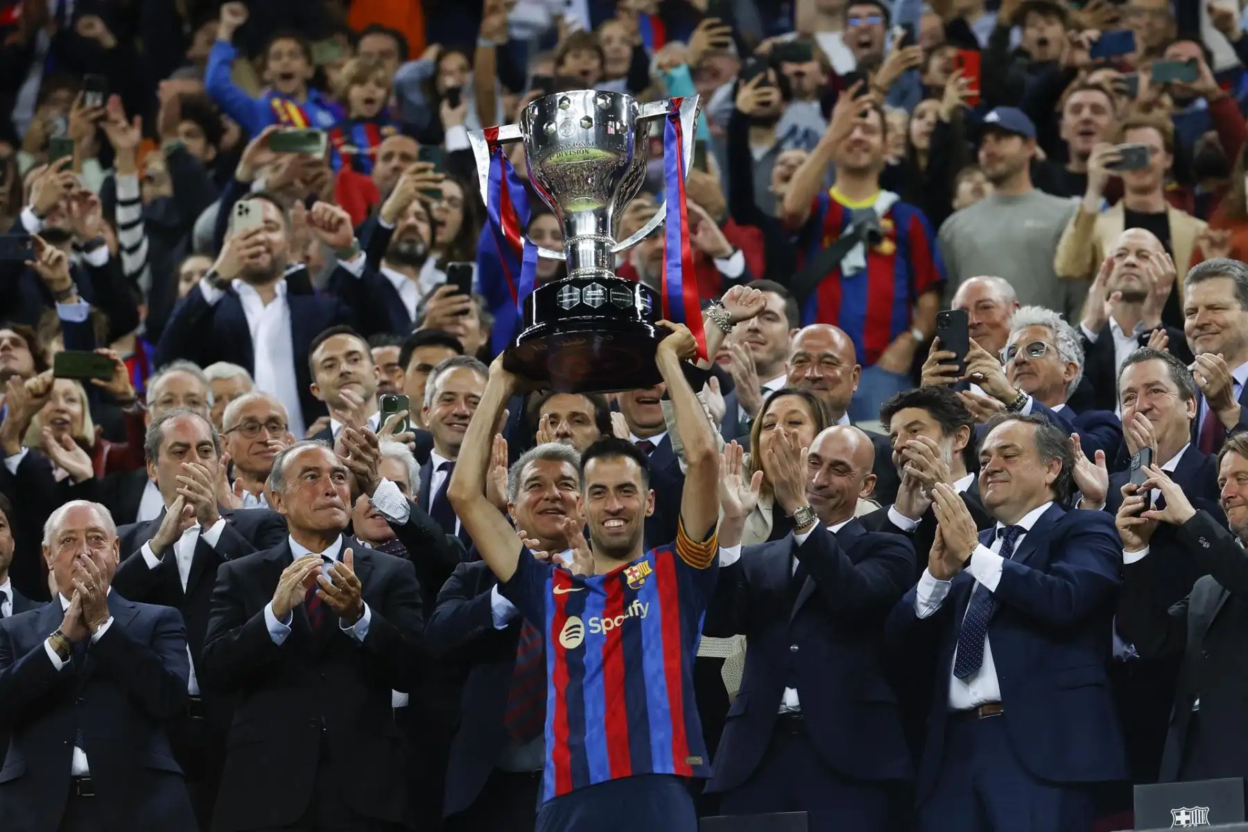 El capitán del FC Barcelona Sergio Busquets (c) levanta la copa de campeones de LaLiga Santander 22-23 al término del partido correspondiente a la jornada 35 de LaLiga Santander este sábado en el Spotify Camp Nou (Barcelona). Junto al capitán blaugrana se encuentra Luis Rubiales (2d) presidente de la RFEF y detrás Joan Laporta, presidente del club
Foto: EFE