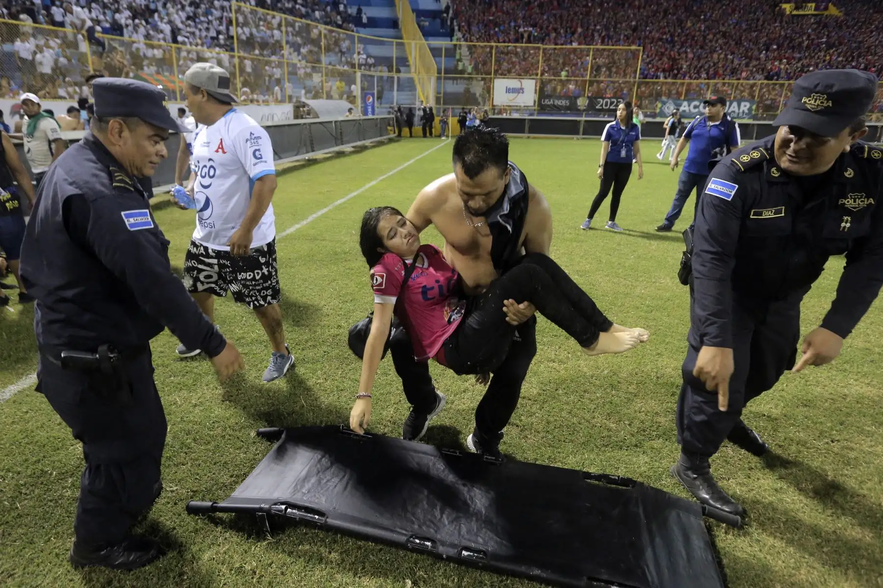Los simpatizantes son ayudados por otros luego de una estampida durante un partido de fútbol entre Alianza y FAS en el estadio Cuscatlán en San Salvador. Foto:ANDINA/AFP