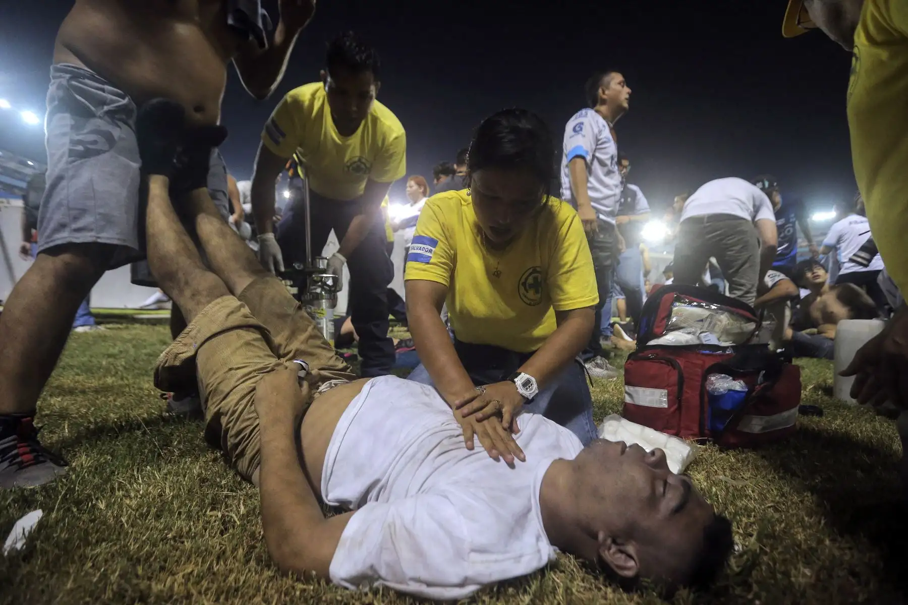 Los rescatistas atienden a un hombre herido que yacía en la cancha luego de una estampida durante un partido de fútbol entre Alianza y FAS en el estadio Cuscatlán en San Salvador.Foto:ANDINA/AFP
