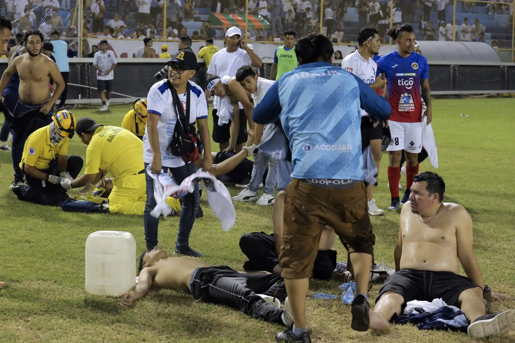 Los simpatizantes son ayudados por otros luego de una estampida durante un partido de fútbol entre Alianza y FAS en el estadio Cuscatlán en San Salvador.  Nueve personas murieron. Foto:ANDINA/AFP