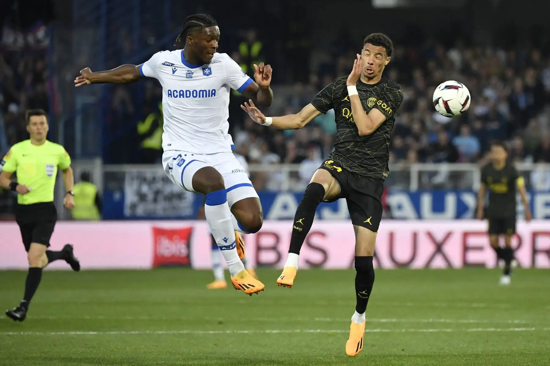 Isaak Toure, defensor francés de Auxerre, y Hugo Ekitike, delantero francés de Paris Saint-Germain, saltan por el balón durante el partido de fútbol francés L1 entre AJ Auxerre y Paris Saint-Germain (PSG). Foto:ANDINA/AFP
