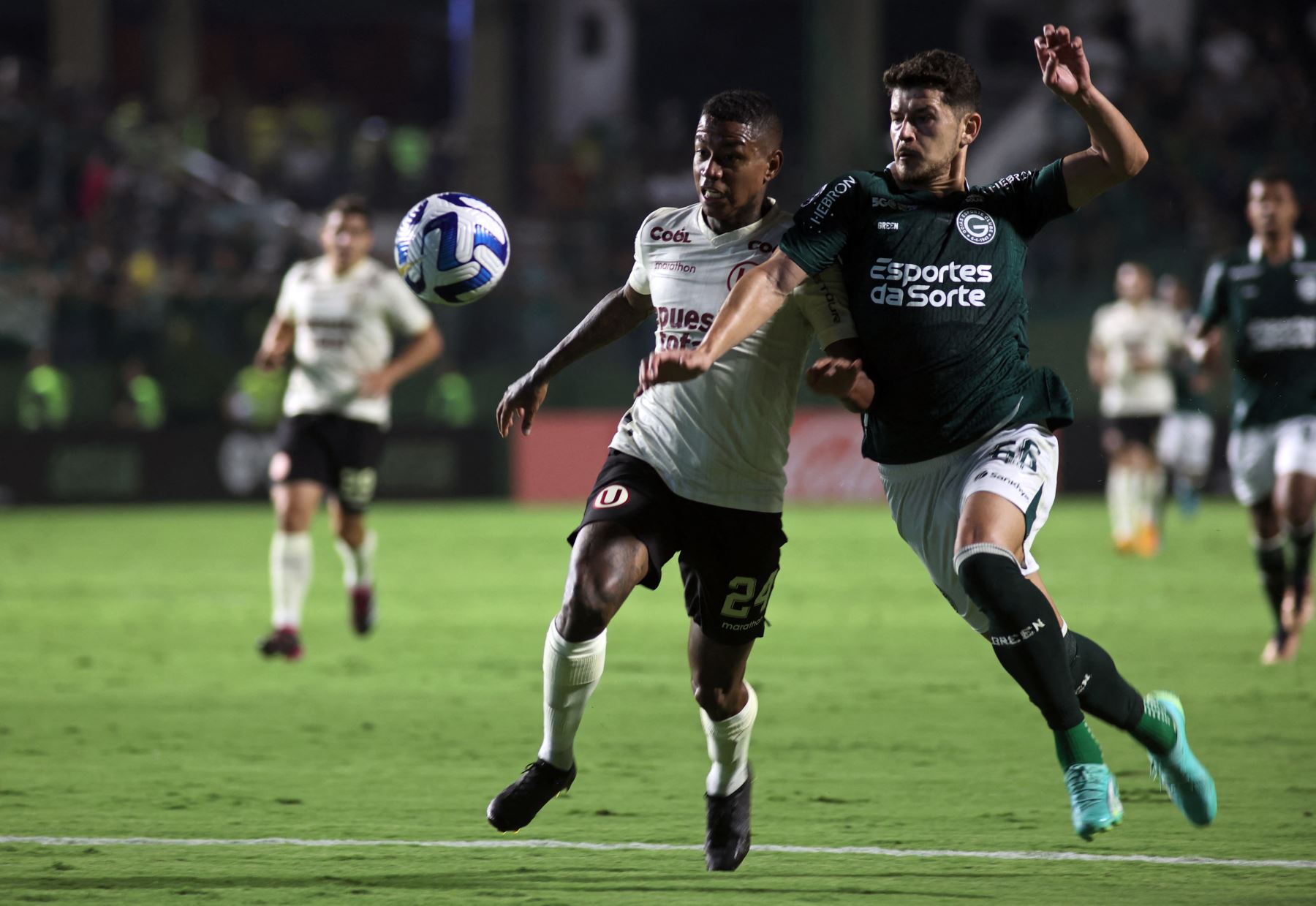 El delantero de Universitario Andy Polo y el defensa de Goiás Hugo compiten por el balón durante el partido de vuelta de la fase de grupos de la Copa Sudamericana. Foto: AFP