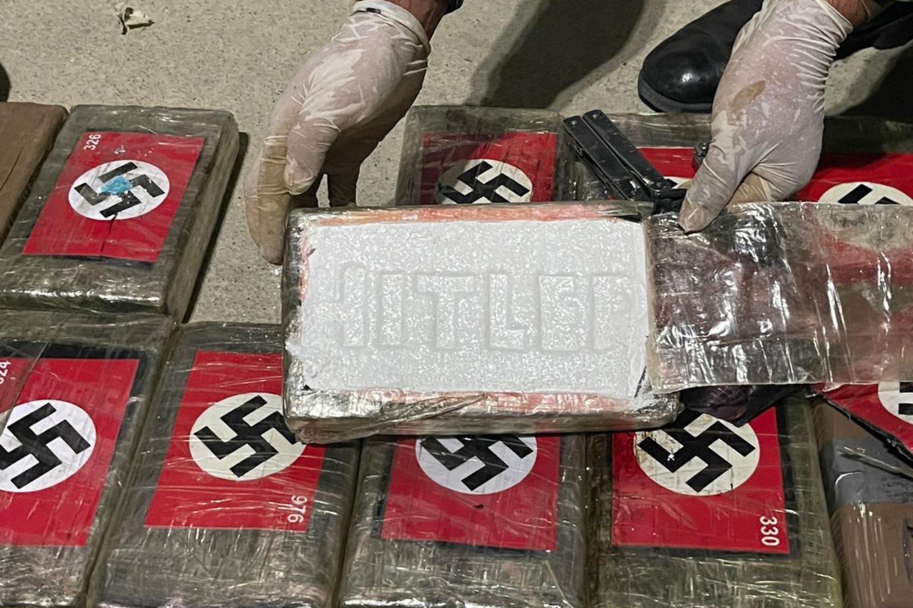 Fotografía cedida hoy por la Policía Nacional del Perú que muestra un alijo de cocaína marcado con símbolos nazis, decomisado en el puerto de Paita, departamento de Piura (Perú). Las autoridades peruanas incautaron un alijo de 57 kilos de cocaína que estaba marcado con decenas de esvásticas y empacada en forma de ladrillos sellados con el nombre "Hitler", Foto: EFE/ Policía Nacional del Perú