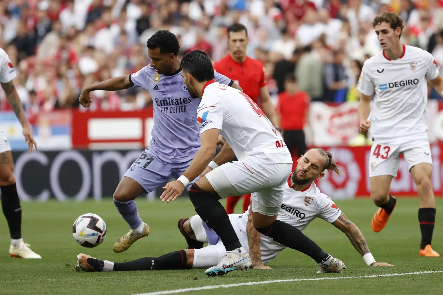 El delantero brasileño del Real Madrid Rodrygo Goes  pelea un balón con los jugadores del Sevilla Nemanja Gudelj y Karim Rekik durante el partido de la jornada 37 de LaLiga disputado este sábado en el Estadio Sánchez Pizjuán. Foto:ANDINA/ EFE