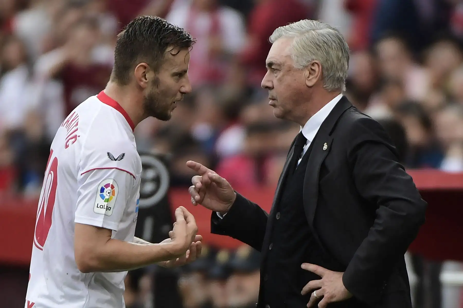 El centrocampista croata del Sevilla Ivan Rakitic habla con el entrenador italiano del Real Madrid, Carlo Ancelotti, durante el partido de fútbol de la liga española entre el Sevilla FC y el Real Madrid CF. Foto:ANDINA/AFP
