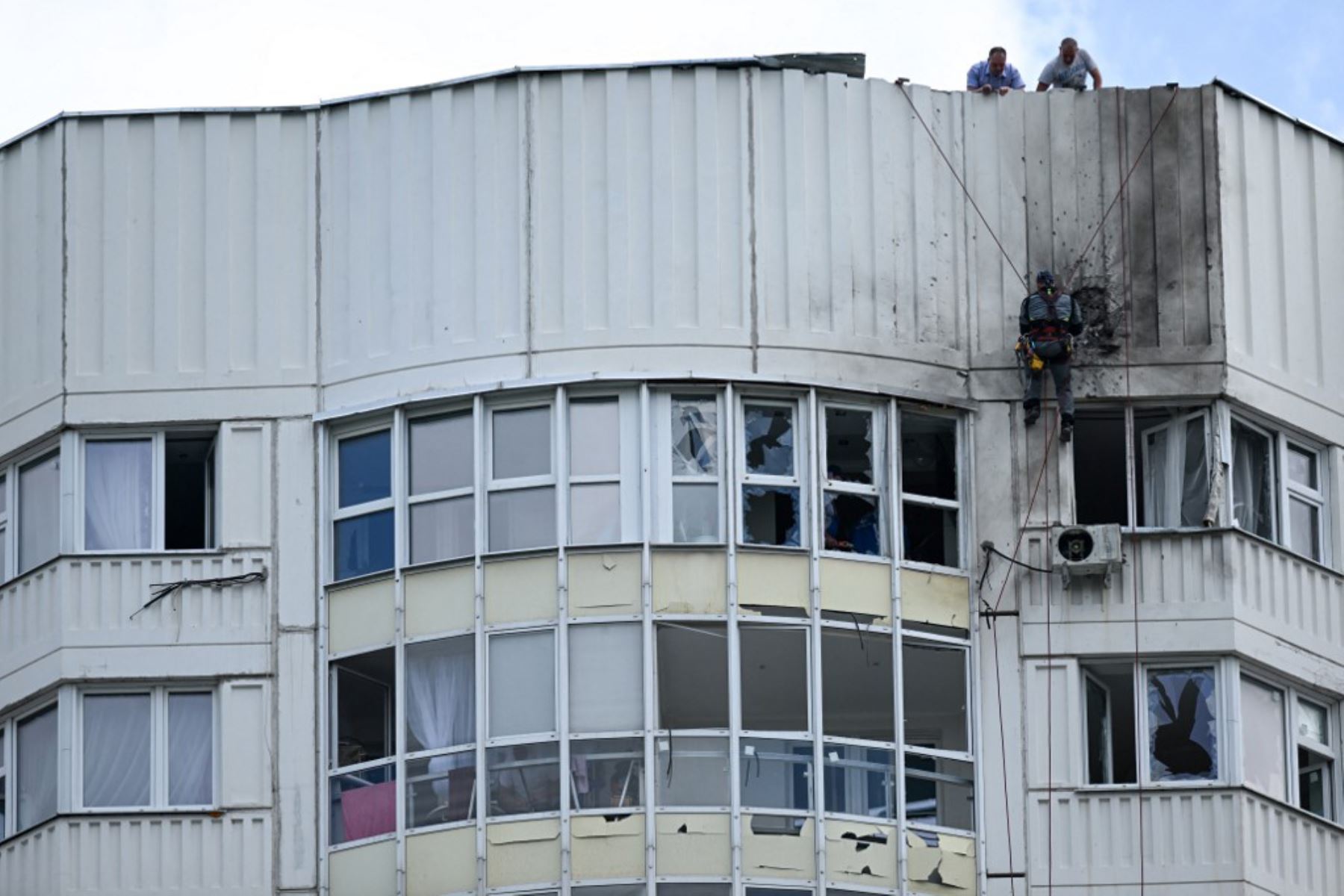 Un especialista inspecciona la fachada dañada de un edificio de apartamentos de varios pisos después de un ataque con drones en Moscú el 30 de mayo de 2023. Foto: AFP